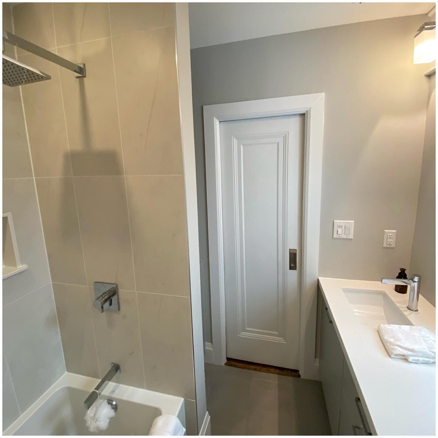 Old is NEW! Refinished and repurposed this original bathroom door, built in the 1940s. We made it into a pocket door for better use of the space. It adds just the right amount of texture to this neutral palate. 

#bathroomdesign #bathroomrenovation #