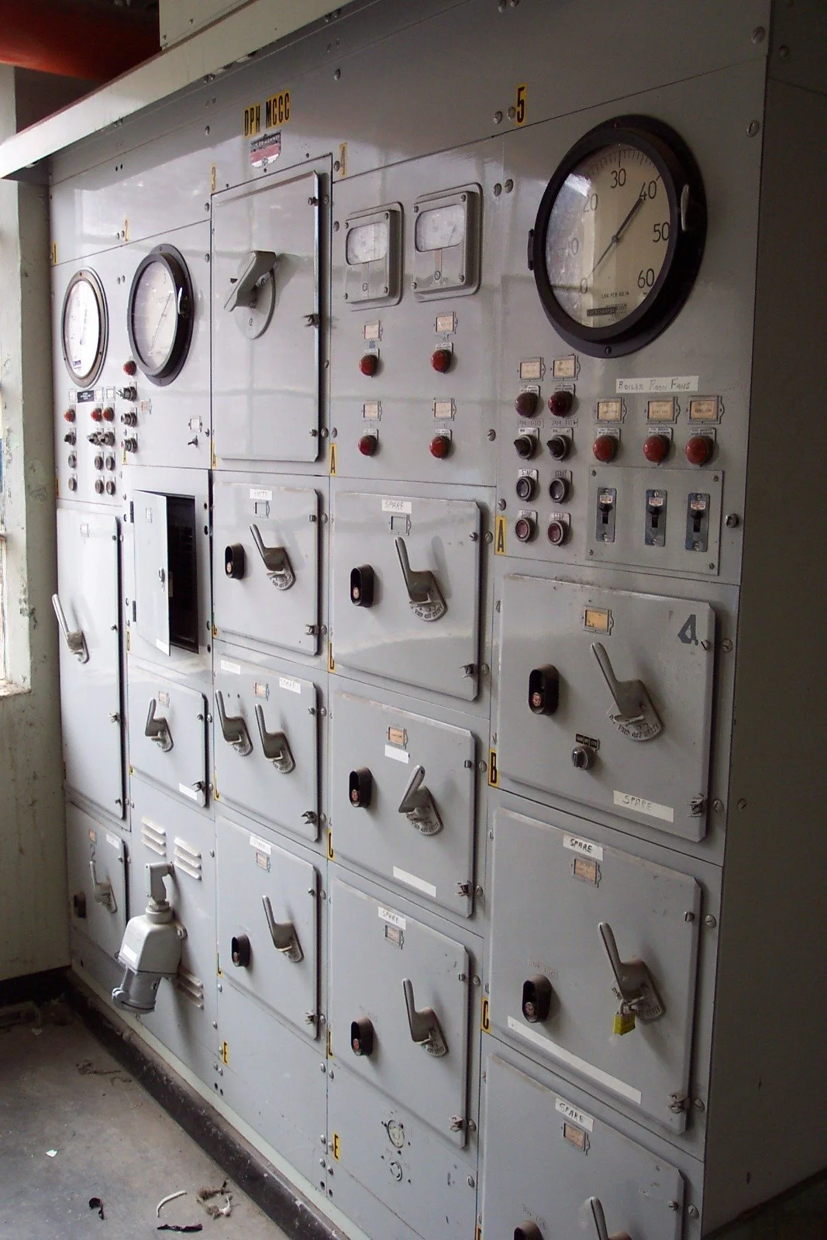 Electrical control panel with switches, gauges, and labels.