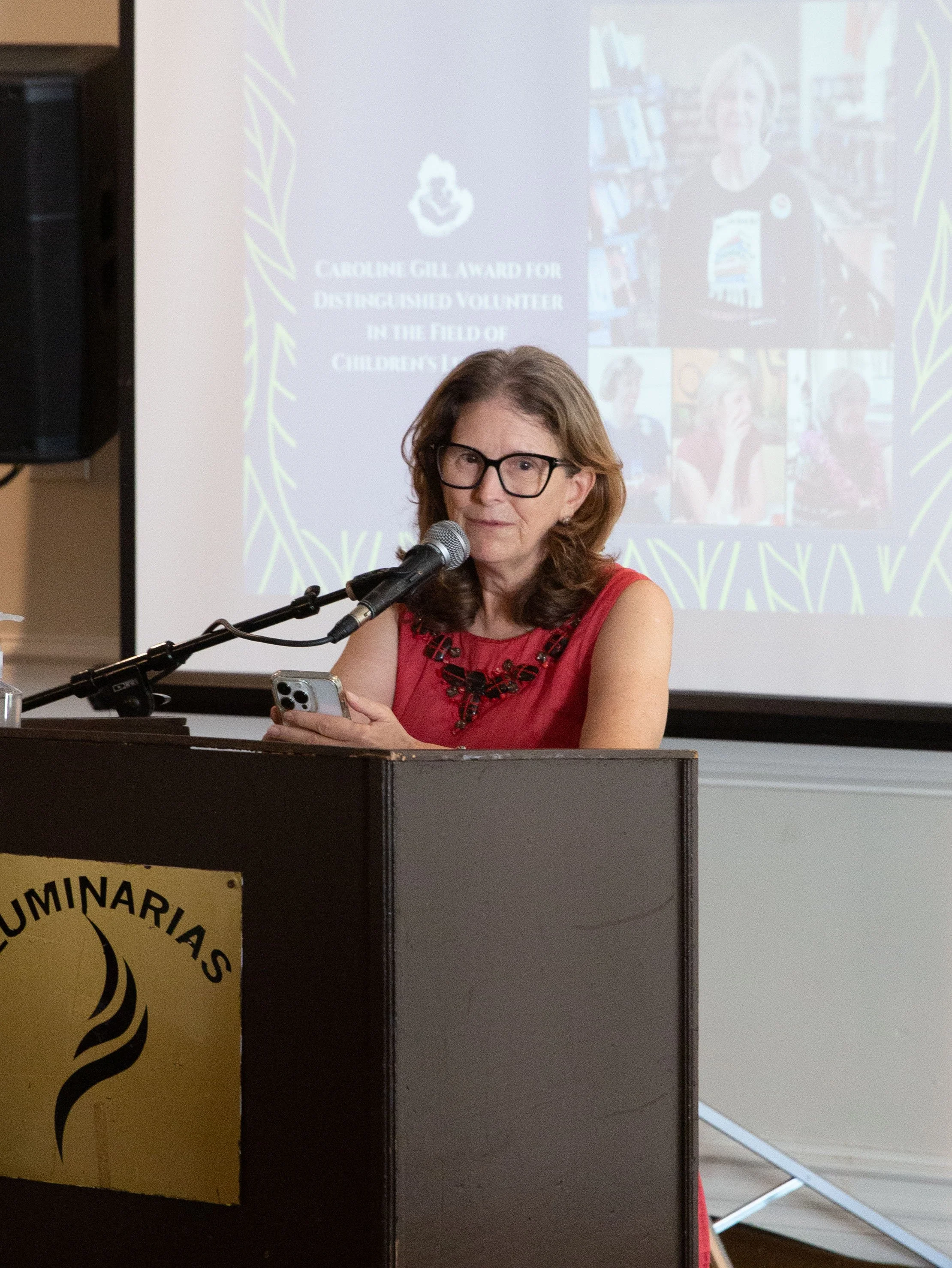 CLCSC Board Member Judith Kantor announces the Caroline Gill Award for Distinguished Volunteer in the Field of Children's Literature. Those gathered held a moment of reverence in memory of both Caroline Gill and beloved children's author Eve Bunting.