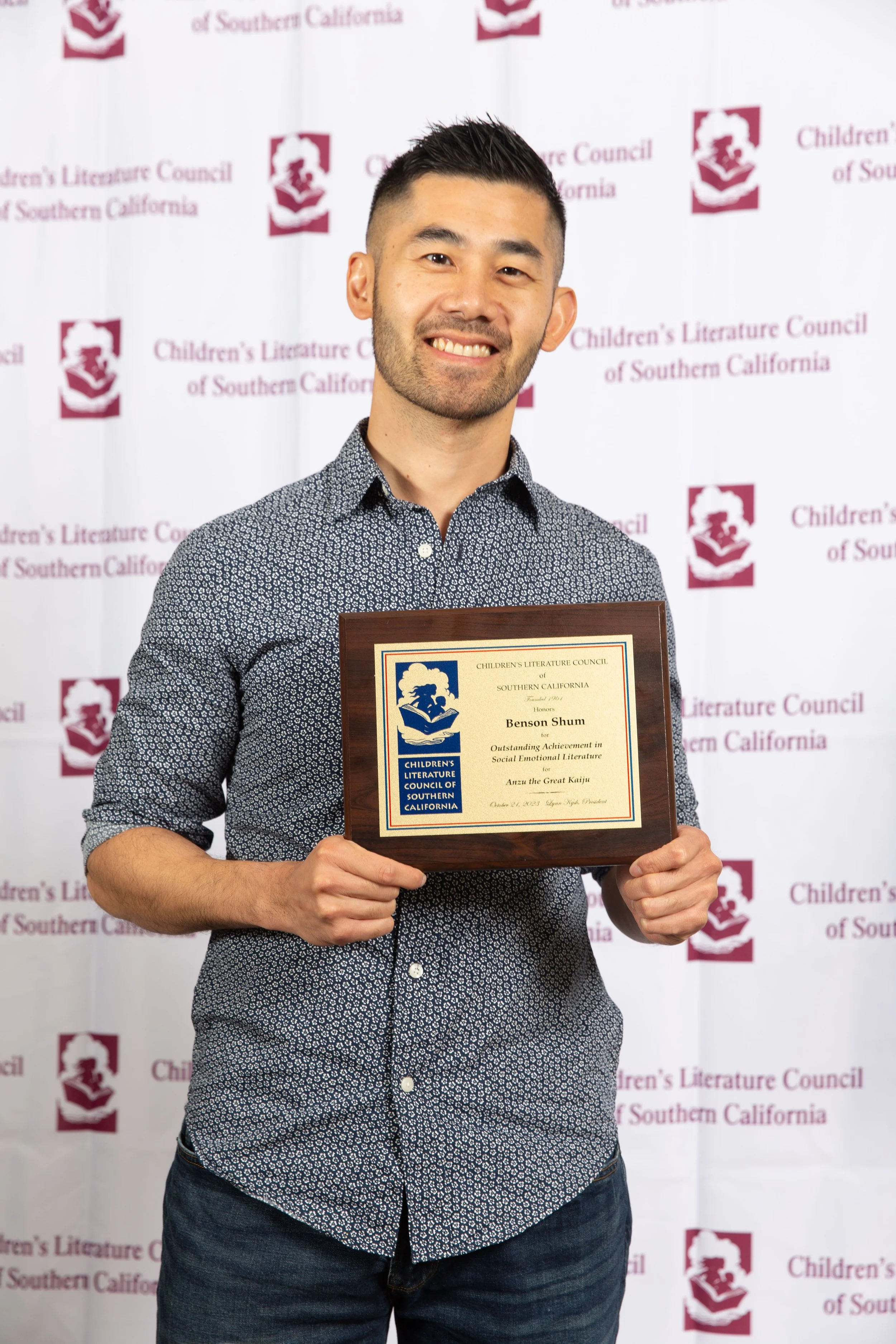 Author/illustrator Benson Shum holds up his award plaque. (Josh Steichmann)