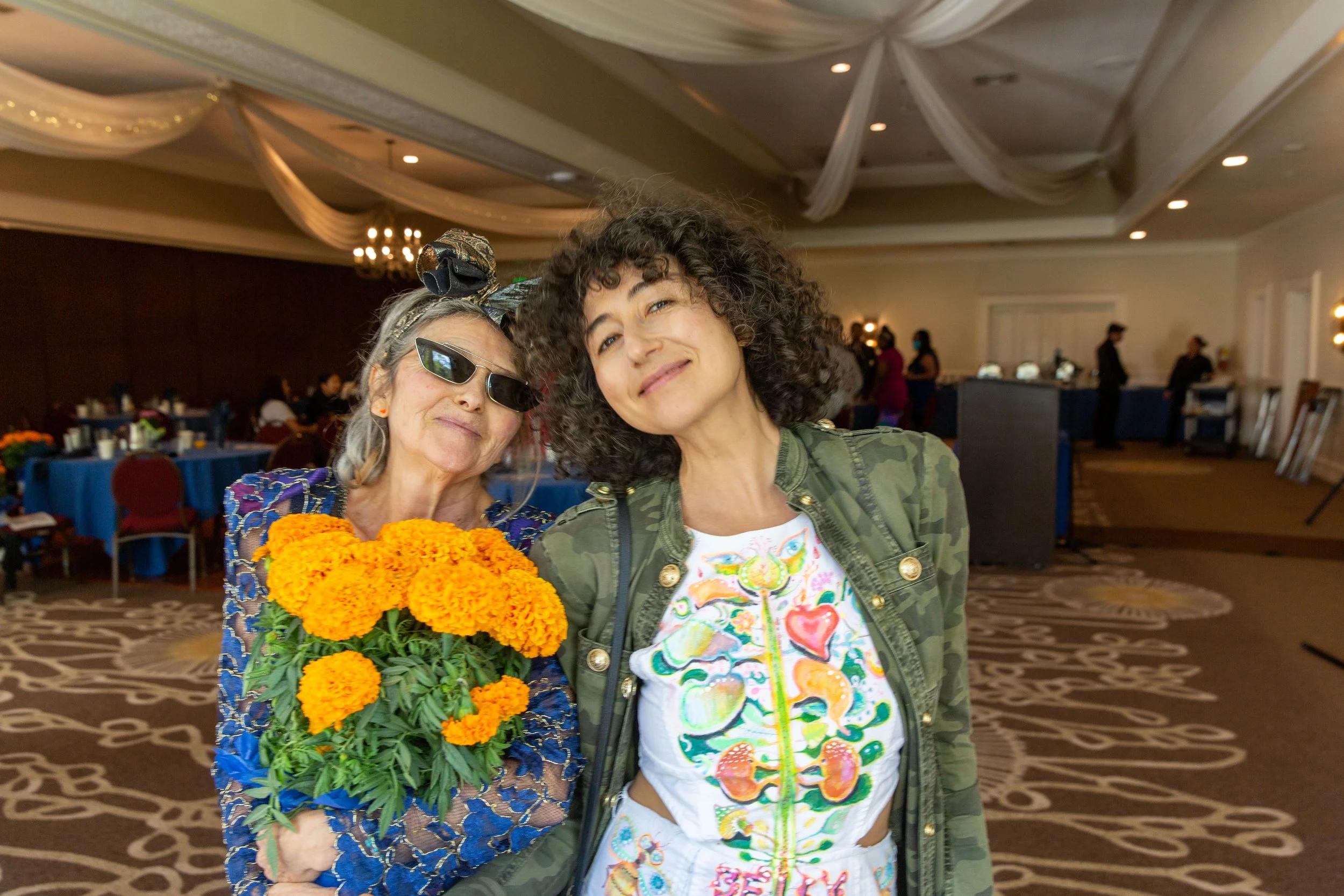 R to L: Award-winning author/illustrator Masha D'yans poses with her mother who is holding a marigold floral centerpiece. (Josh Steichmann)