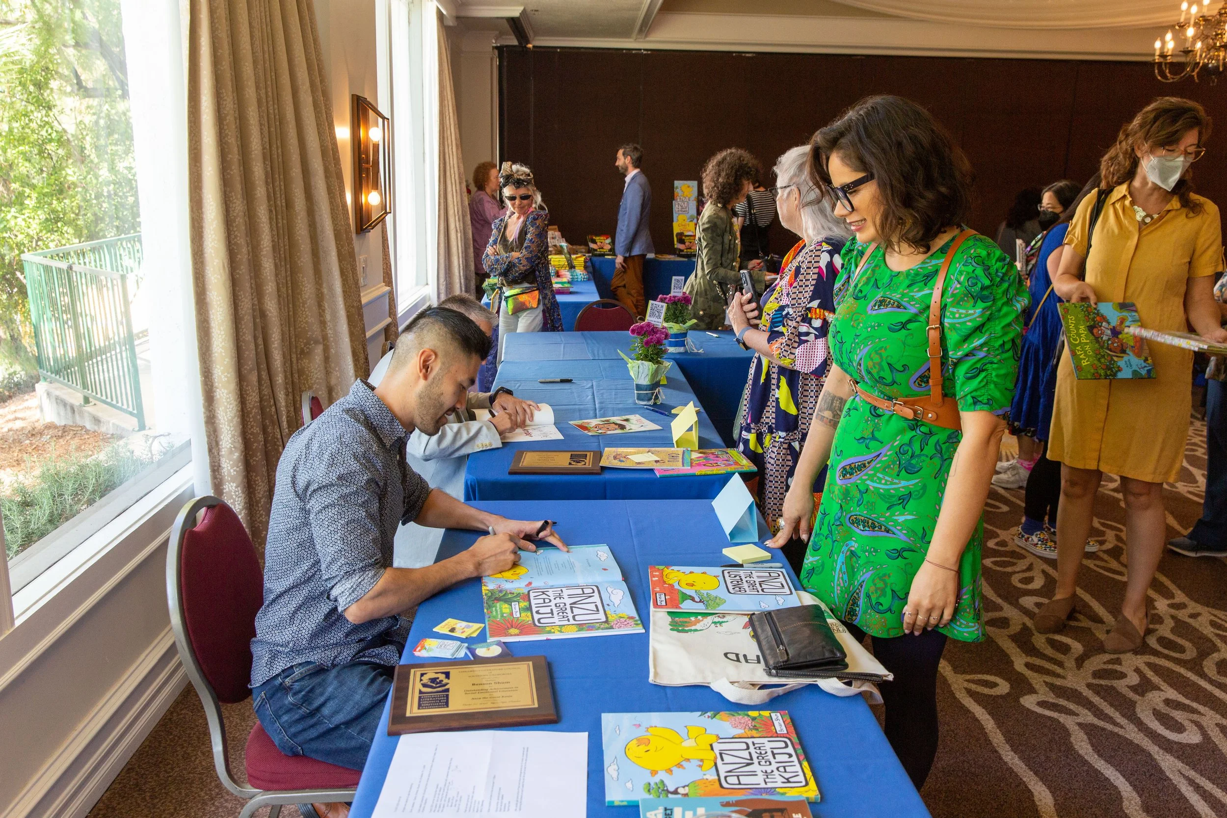 Winner Benson Shum signs a copy of Anzu the Great Kaiju (Josh Steichmann)