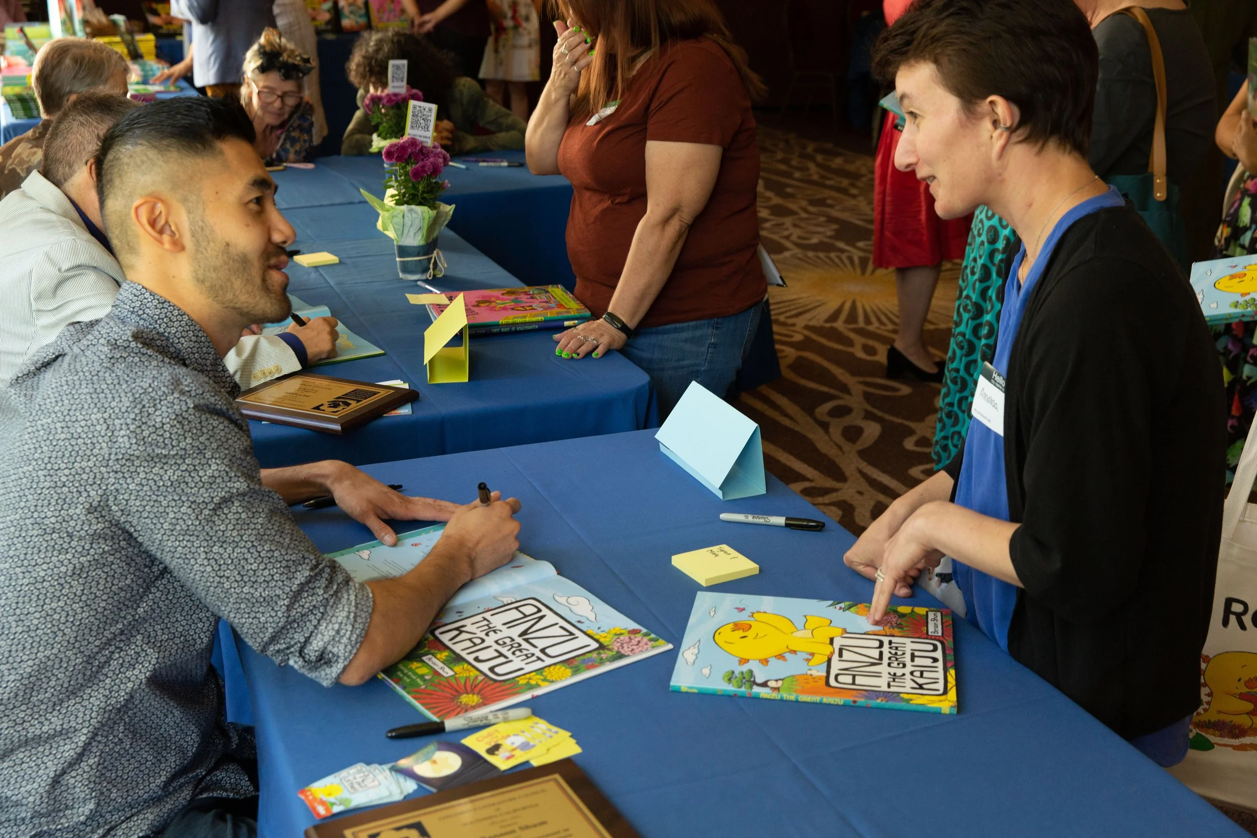 Author-illustrator Benson Shum signs a book while chatting with CLCSC Board Member Annalisa Engh. (Josh Steichmann)