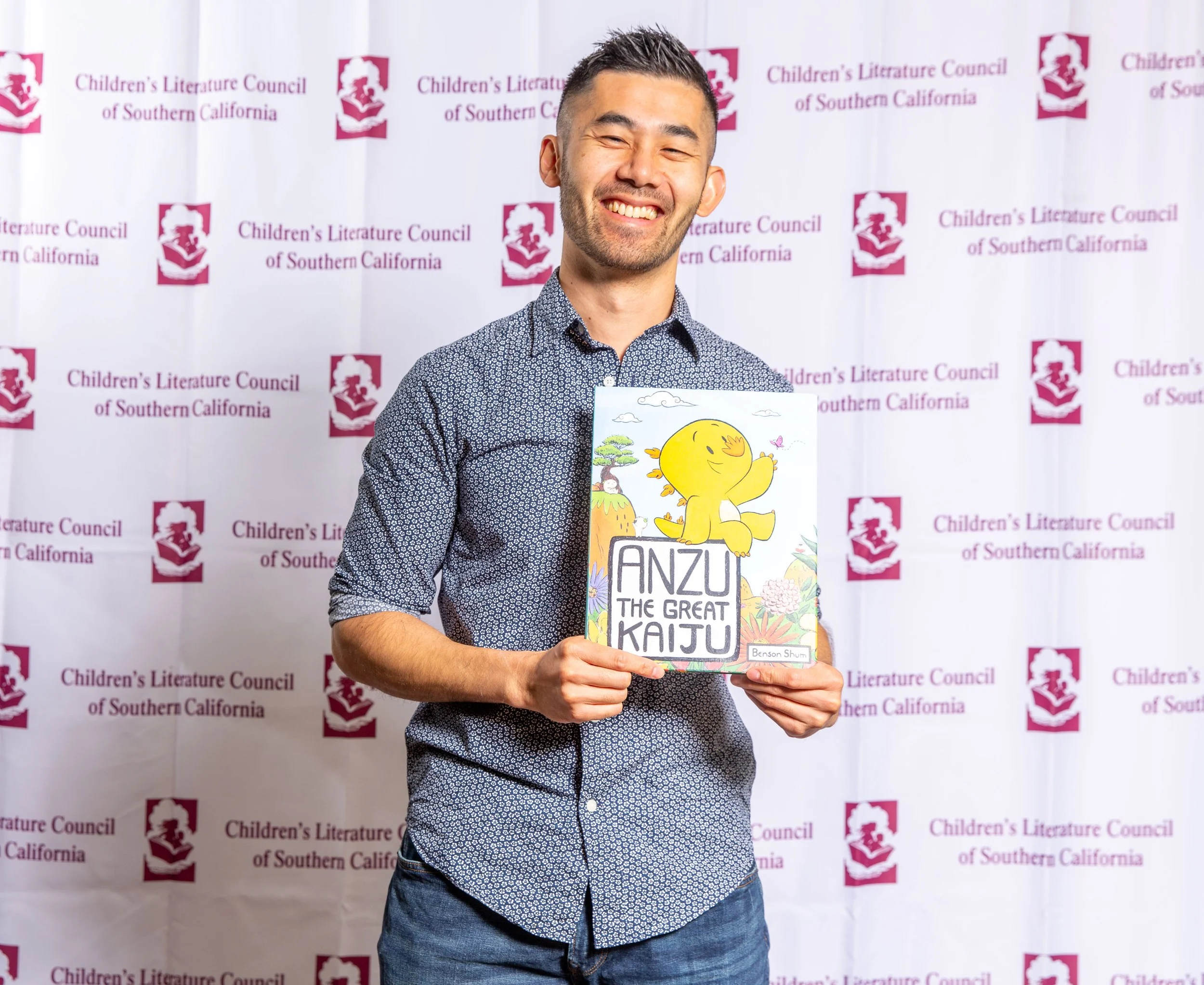 Author & Illustrator Benson Shum holds a copy of Anzu the Great Kaiju, the 2023 CLCSC award winner of the Outstanding Achievement in Social Emotional Literature Award. (Josh Steichmann)