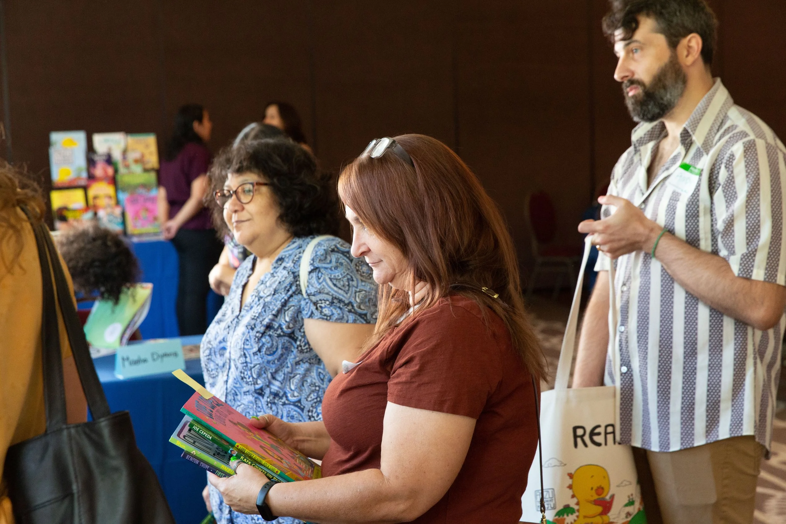 Guests Diane Estrella, Kristen Valenzuela, and Angy Greene wait in line to get their books signed. (Josh Steichmann)