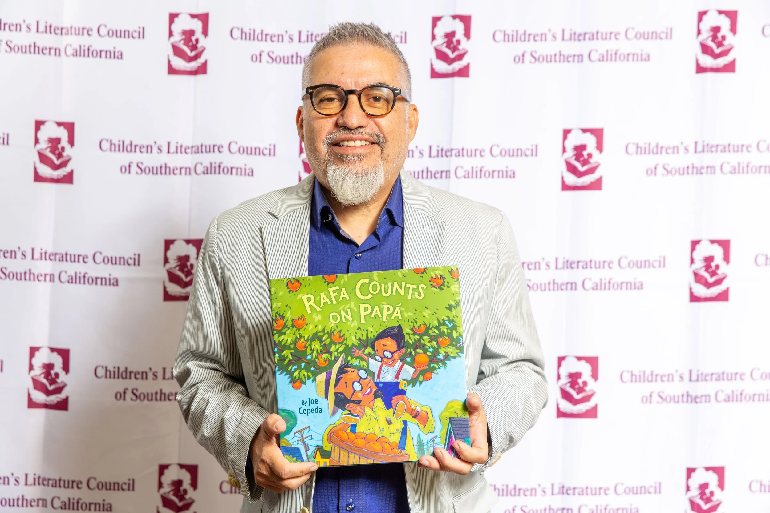 Author & Illustrator Joe Cepeda holds a copy of Rafa Counts on Papá, the 2023 CLCSC award winner of the Excellence in a Picture Book Award. (Josh Steichmann)
