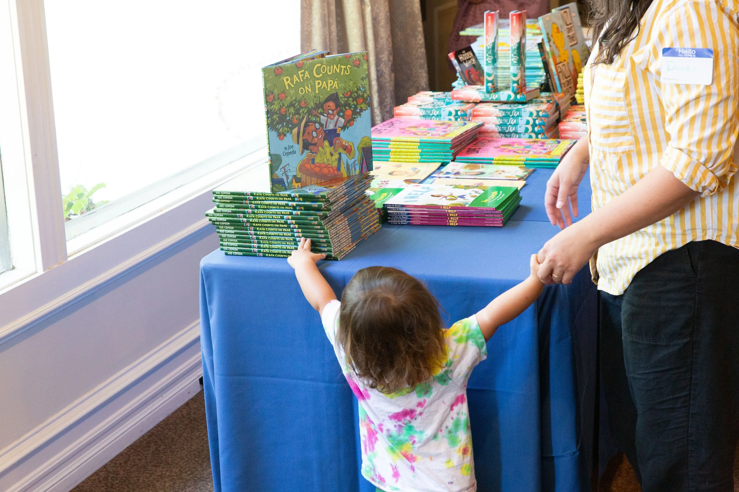 A guest and her toddler peruse books sold by Once Upon a Time Bookstore. (Josh Steichmann)