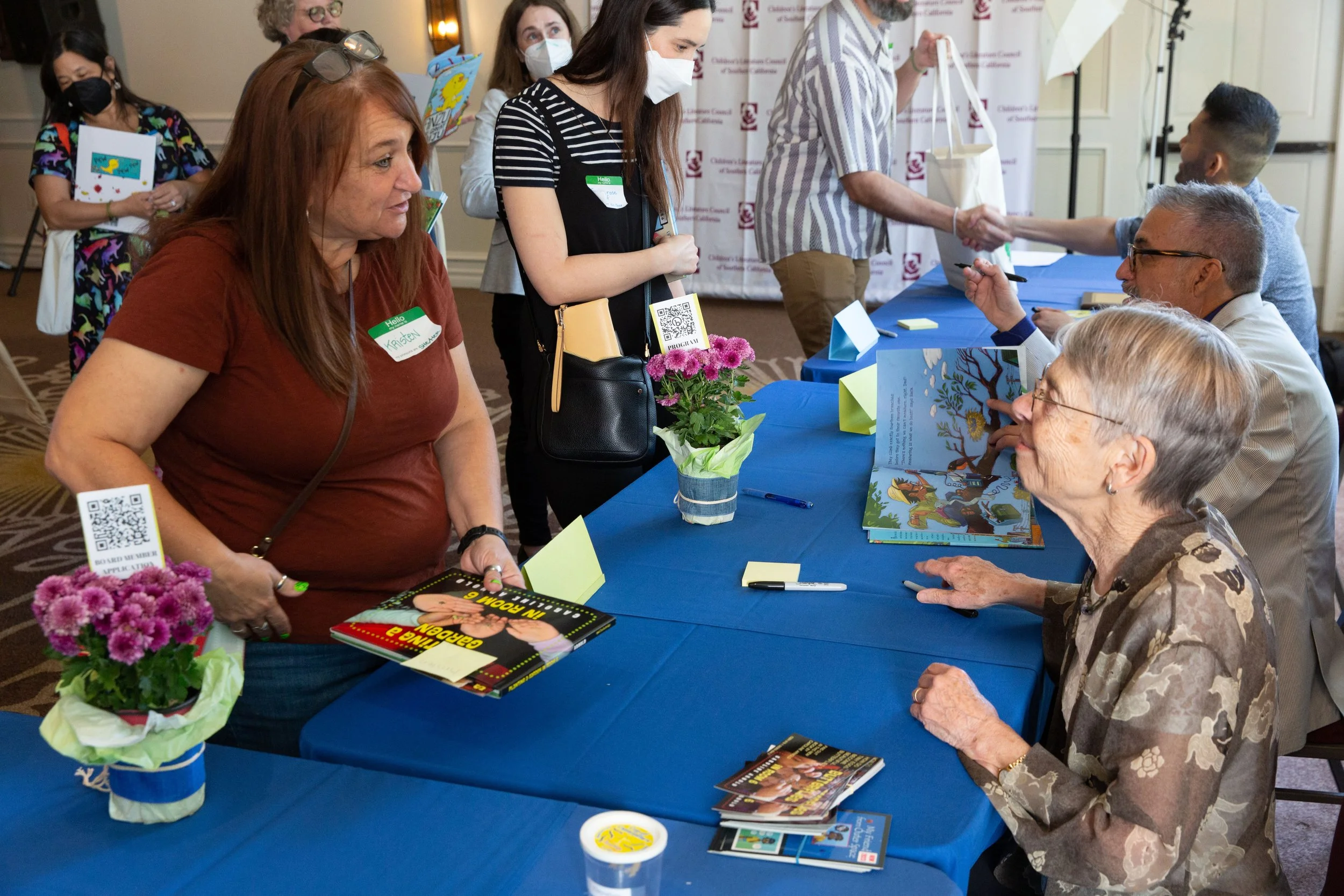 Guest Kristen Valenzuela speaks with author Caroline Arnold at the signing table. (Josh Steichmann)