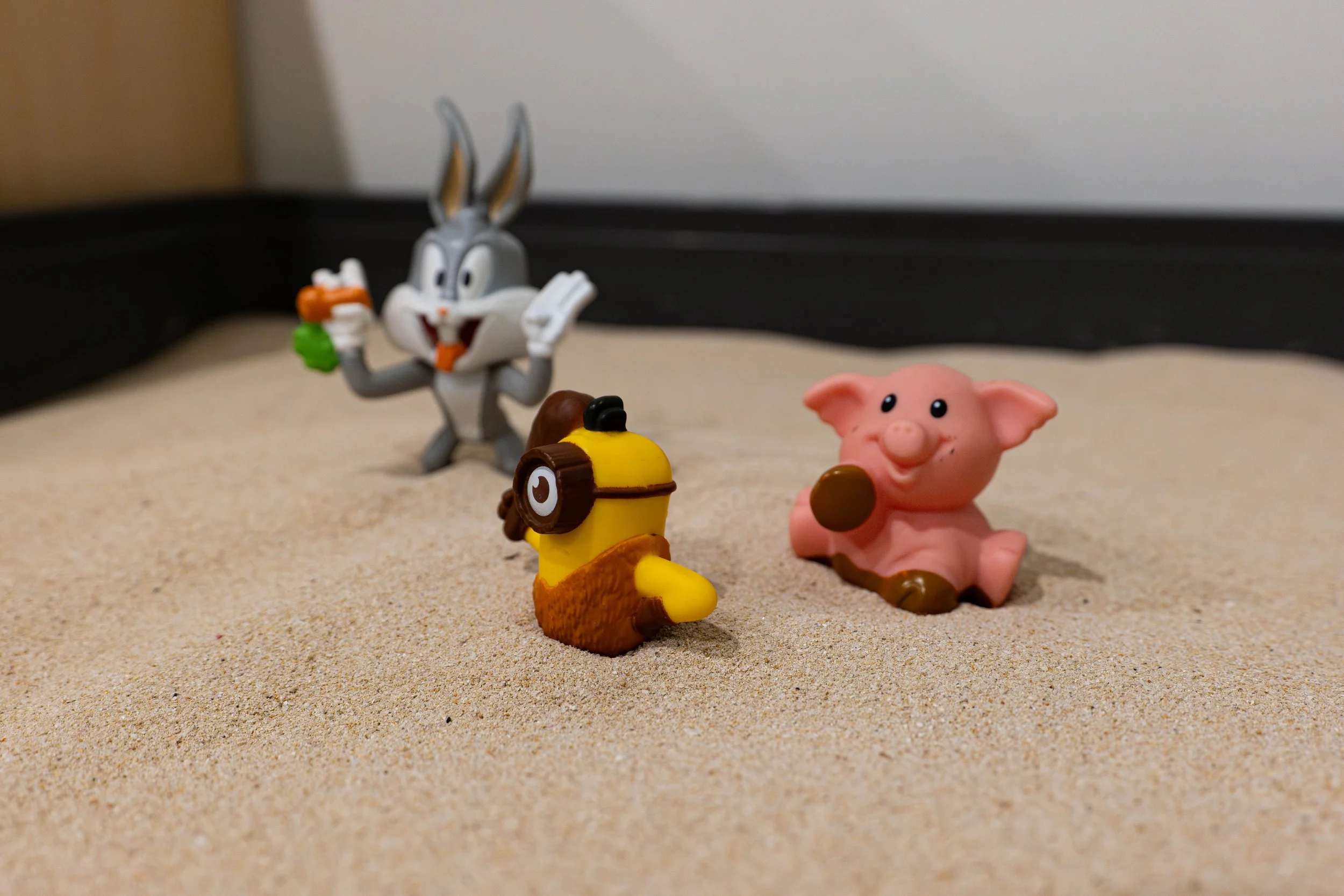 Toys sitting in a sandbox.