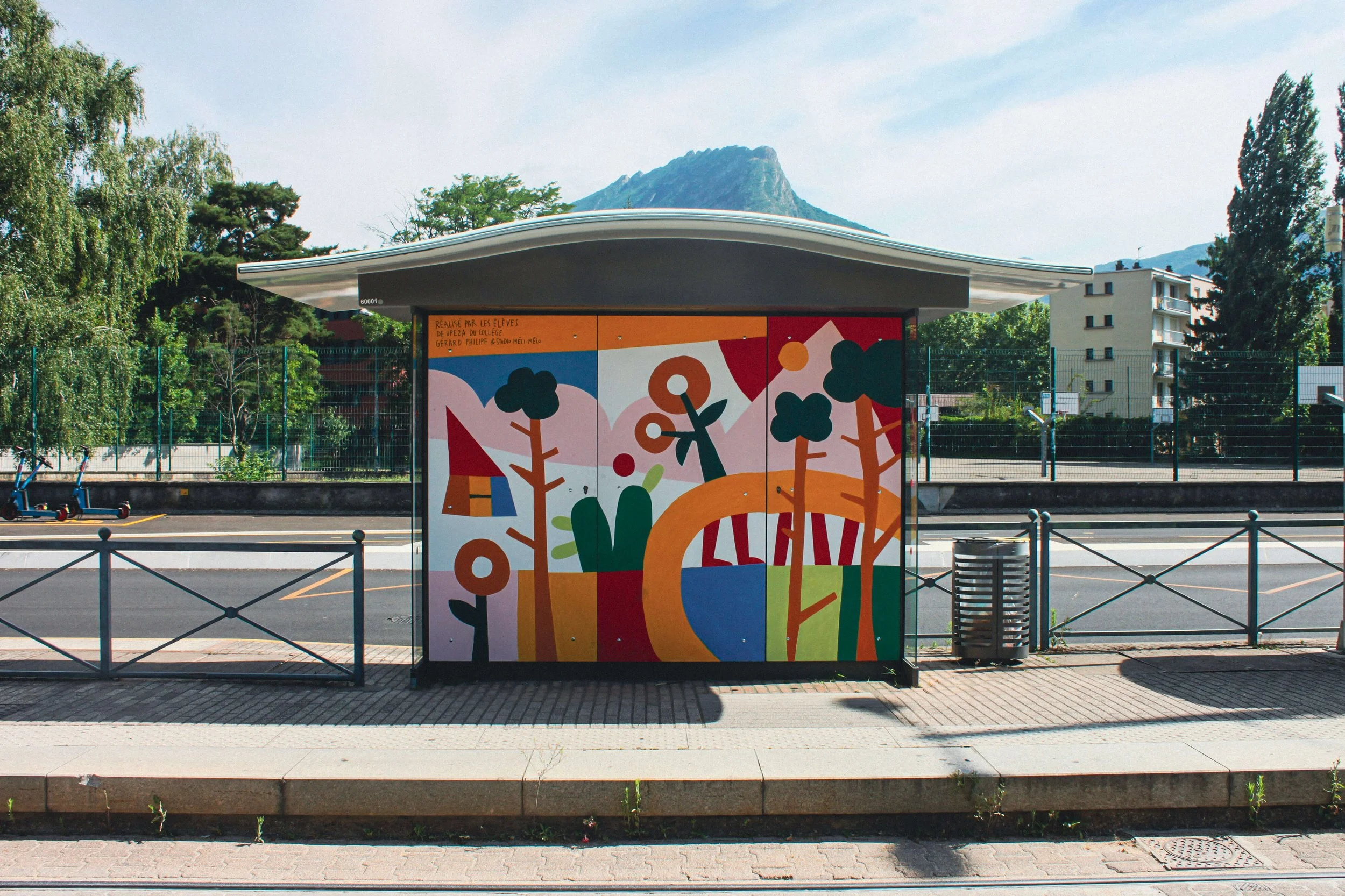 Arret de tram de charles michel à fontaine avec une fresque colorée qui représente la mobilité