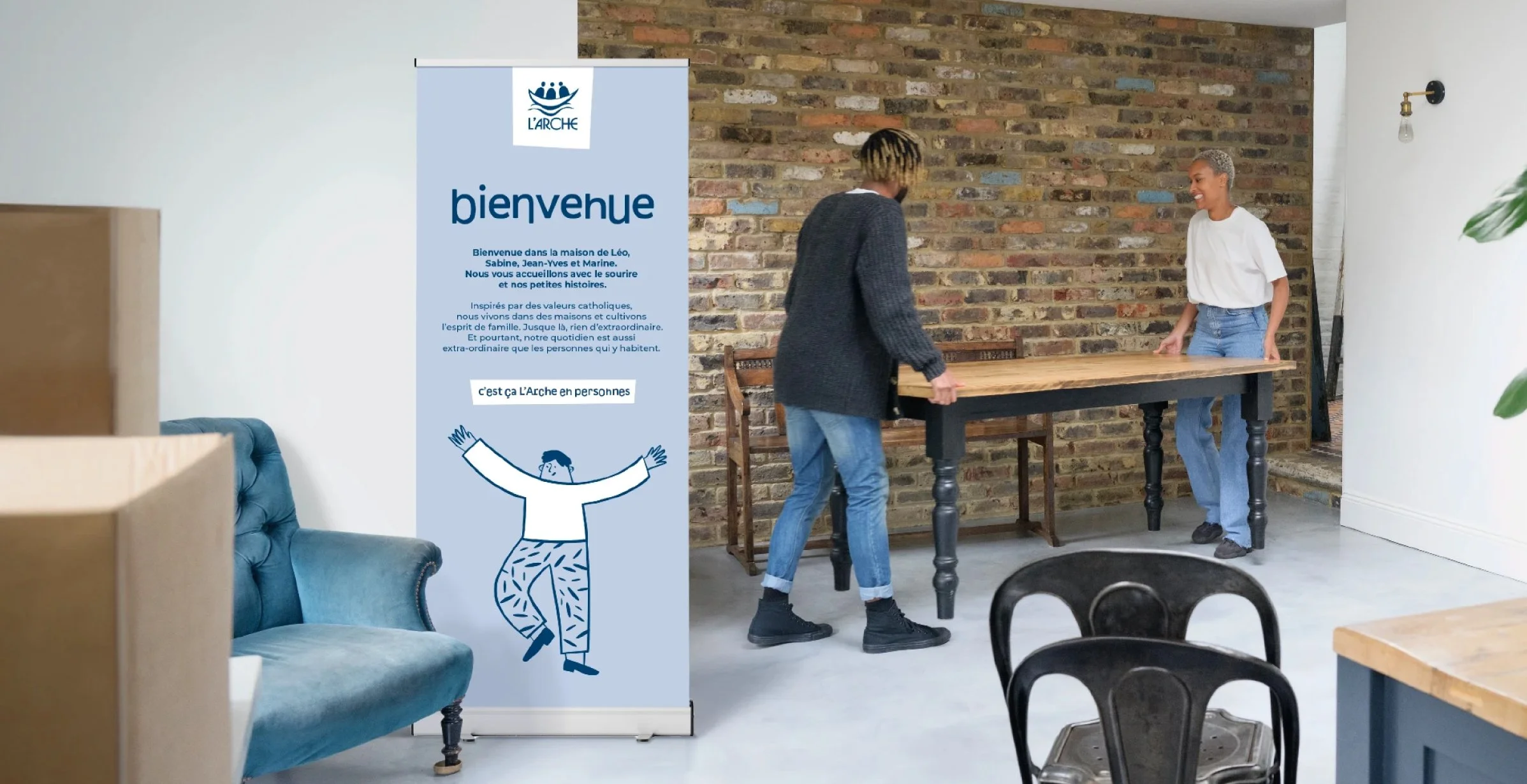 Roll-up avec la nouvelle identité visuelle de l'Arche en France, illustration d'un bonhomme qui ouvre les bras