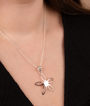 Model wearing silver open flower pendant.png