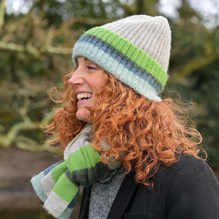 Model wearing ribbed knitted beanie in grey, blue and green