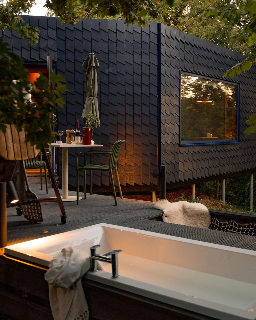 The Nest — an indigo-blue eco-cabin with an outdoor bath and deck at The Bide
