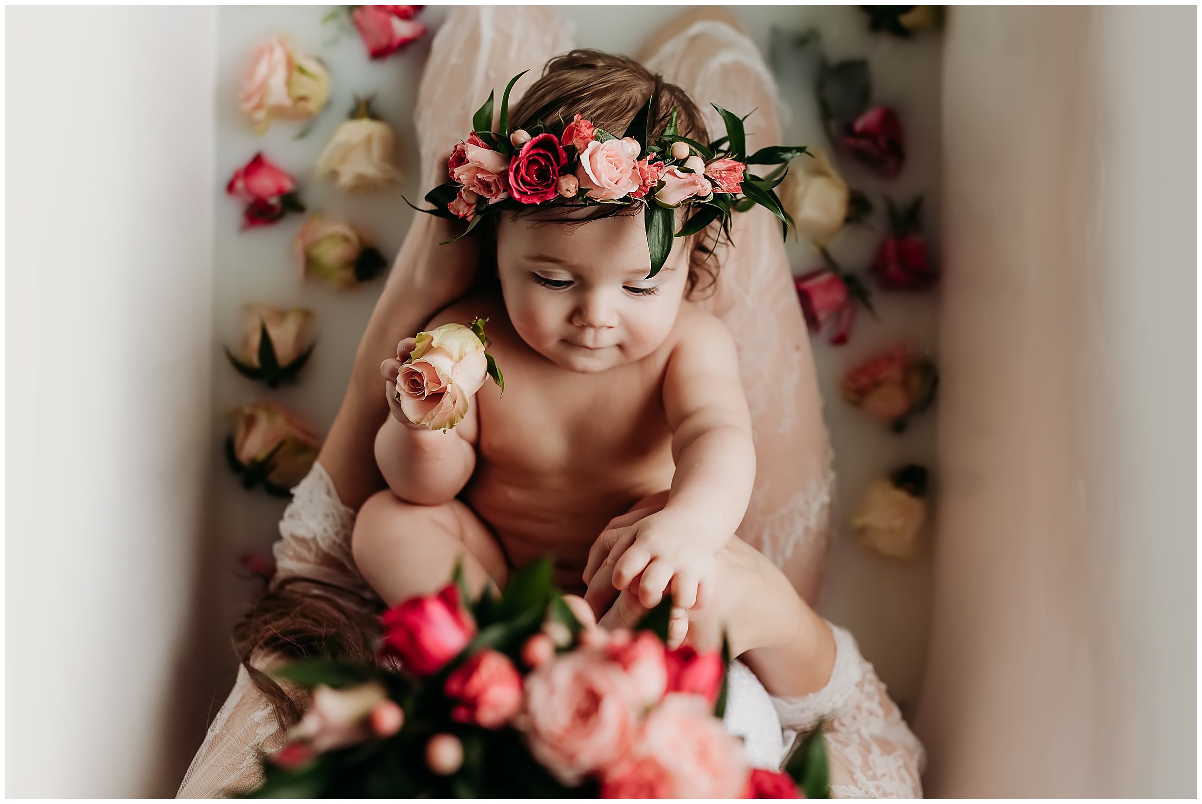 Infant in milk bath with flower crown