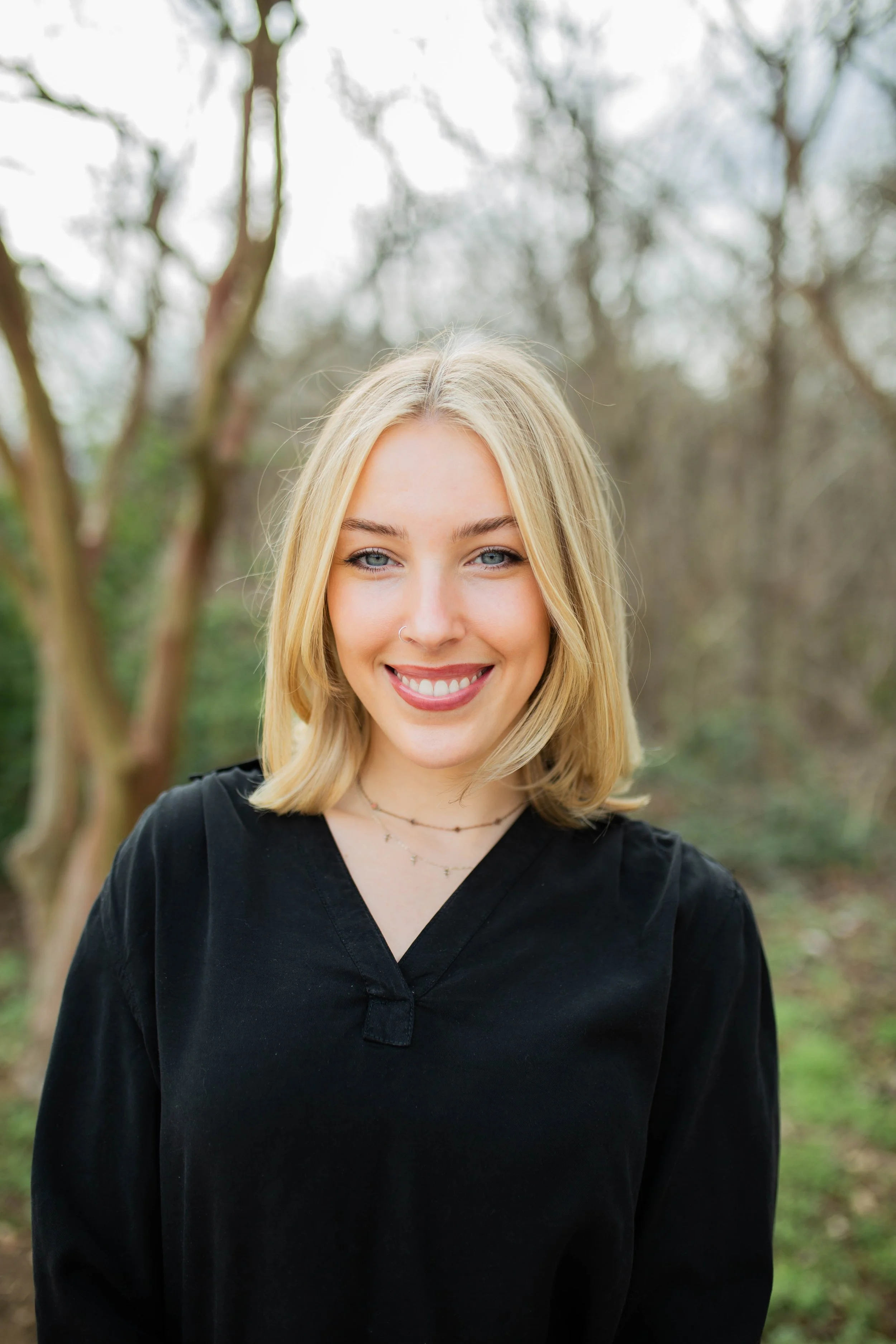A young smiling provisionally licensed therapist outdoors in the late winter weather.