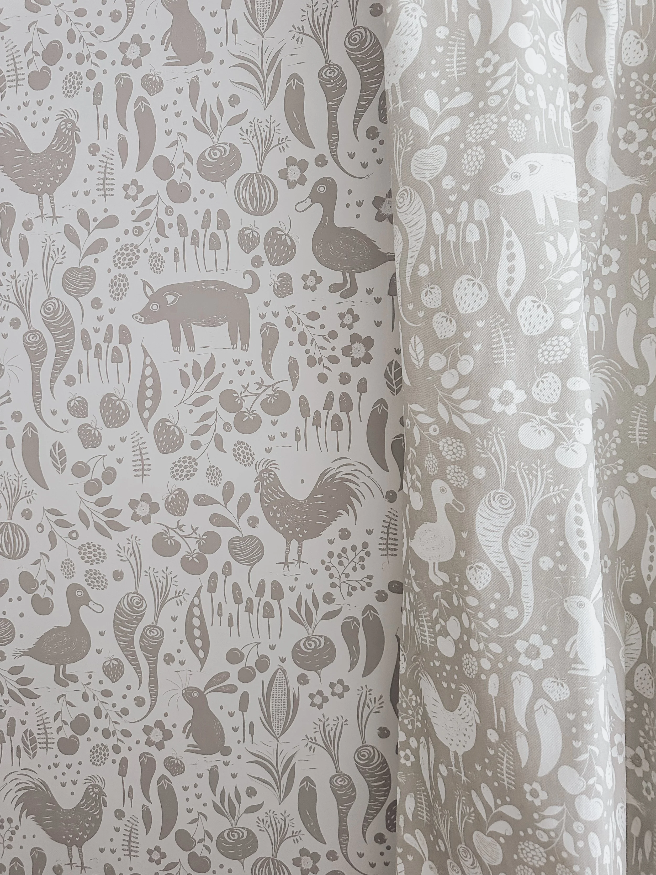 Curtain with a light-colored fabric featuring a pattern of farm animals, plants, and fruits, including ducks, pigs, chickens, rabbits, and various vegetables and berries.