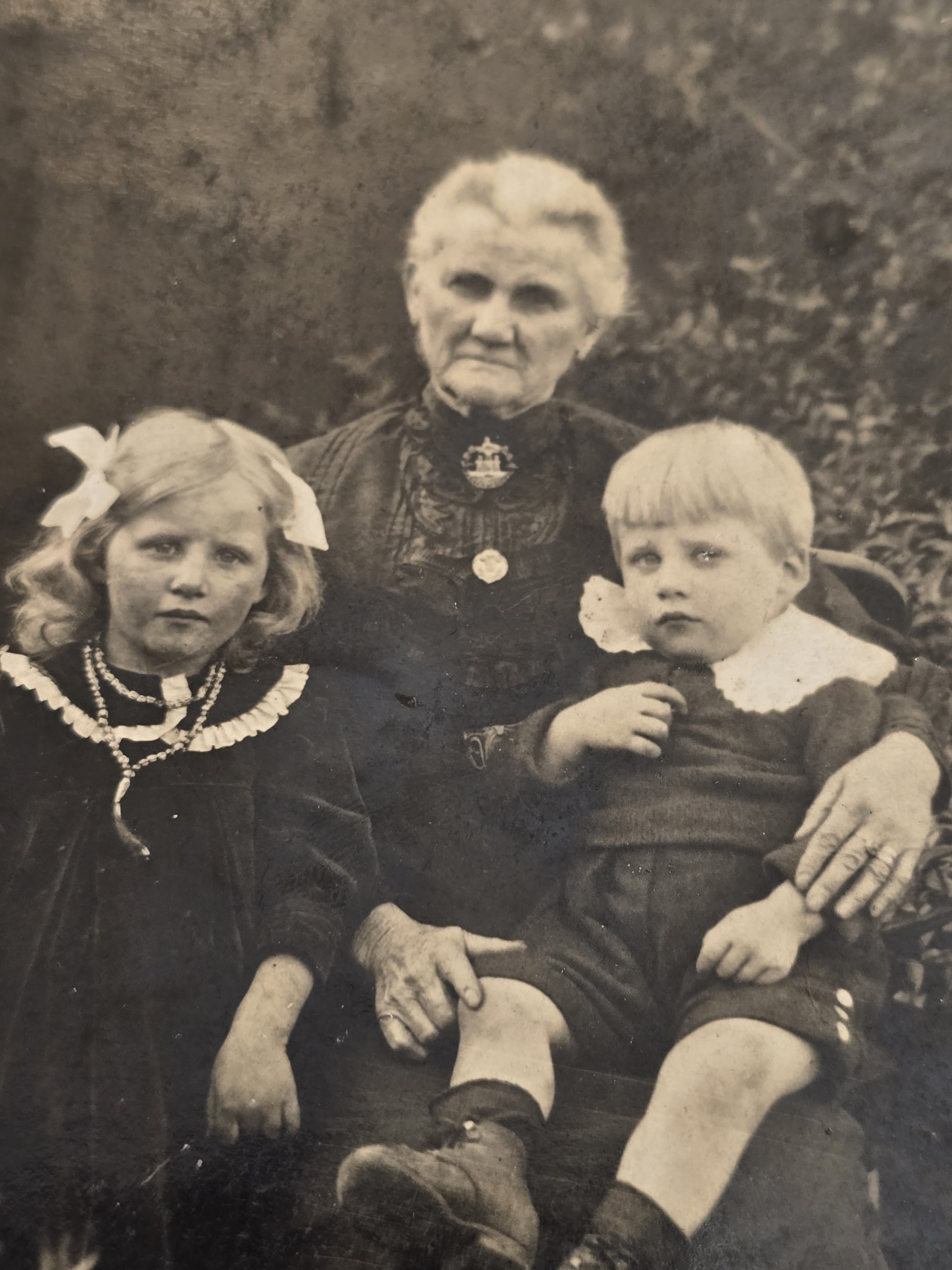 Early 20th-century family photograph showing a mother with four children in period clothing.