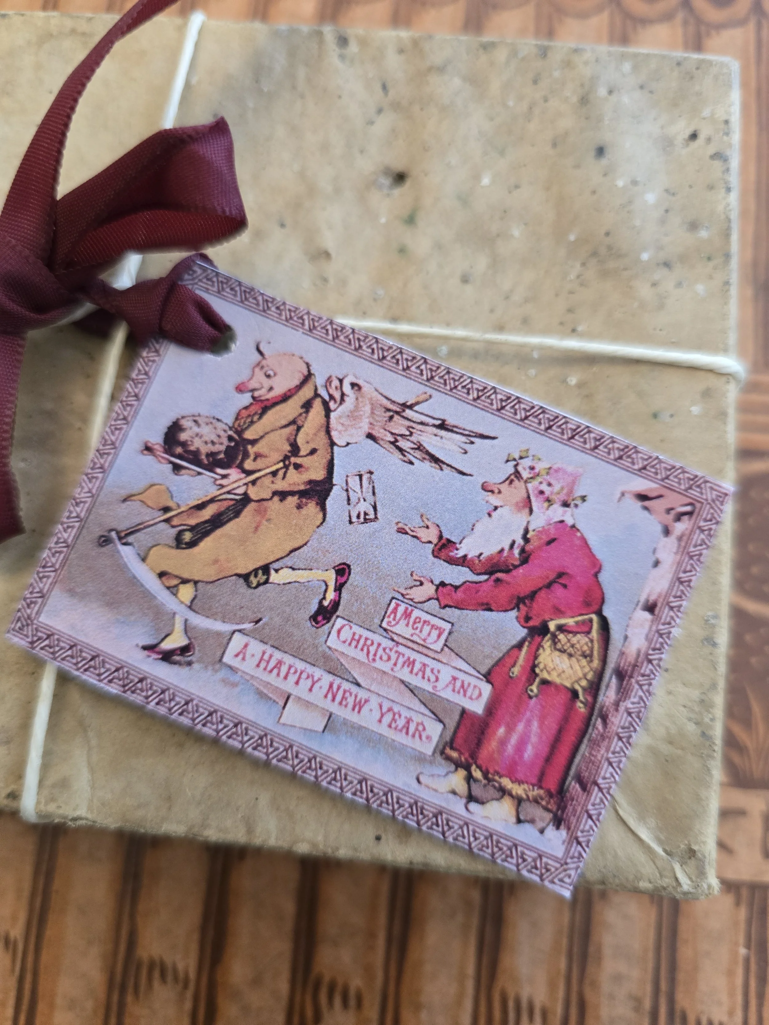 Antique-style printable Christmas gift tag with Father Christmas, a flying bird and a comic festive scene.