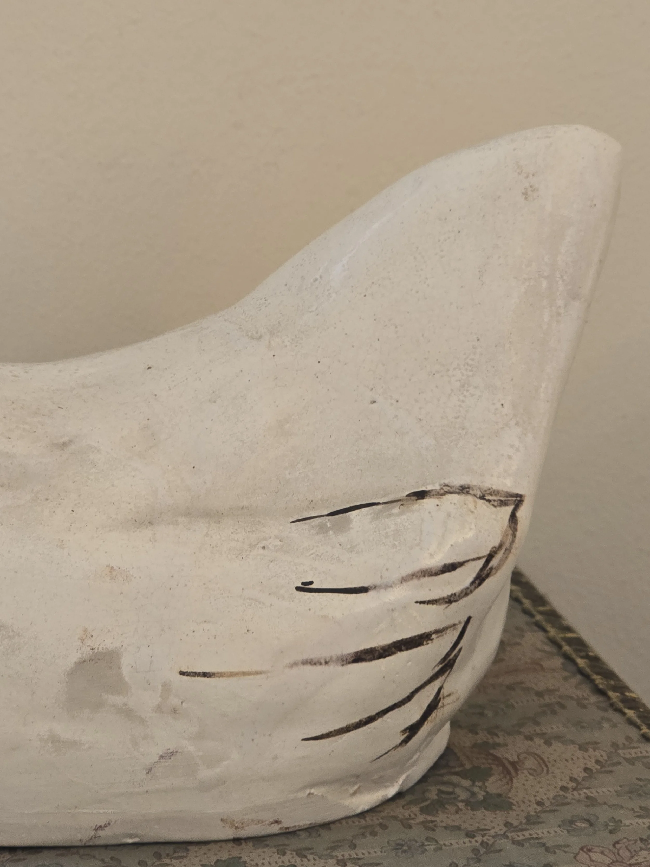 Detail of the tall white tail and remaining hand-painted black wing feathers