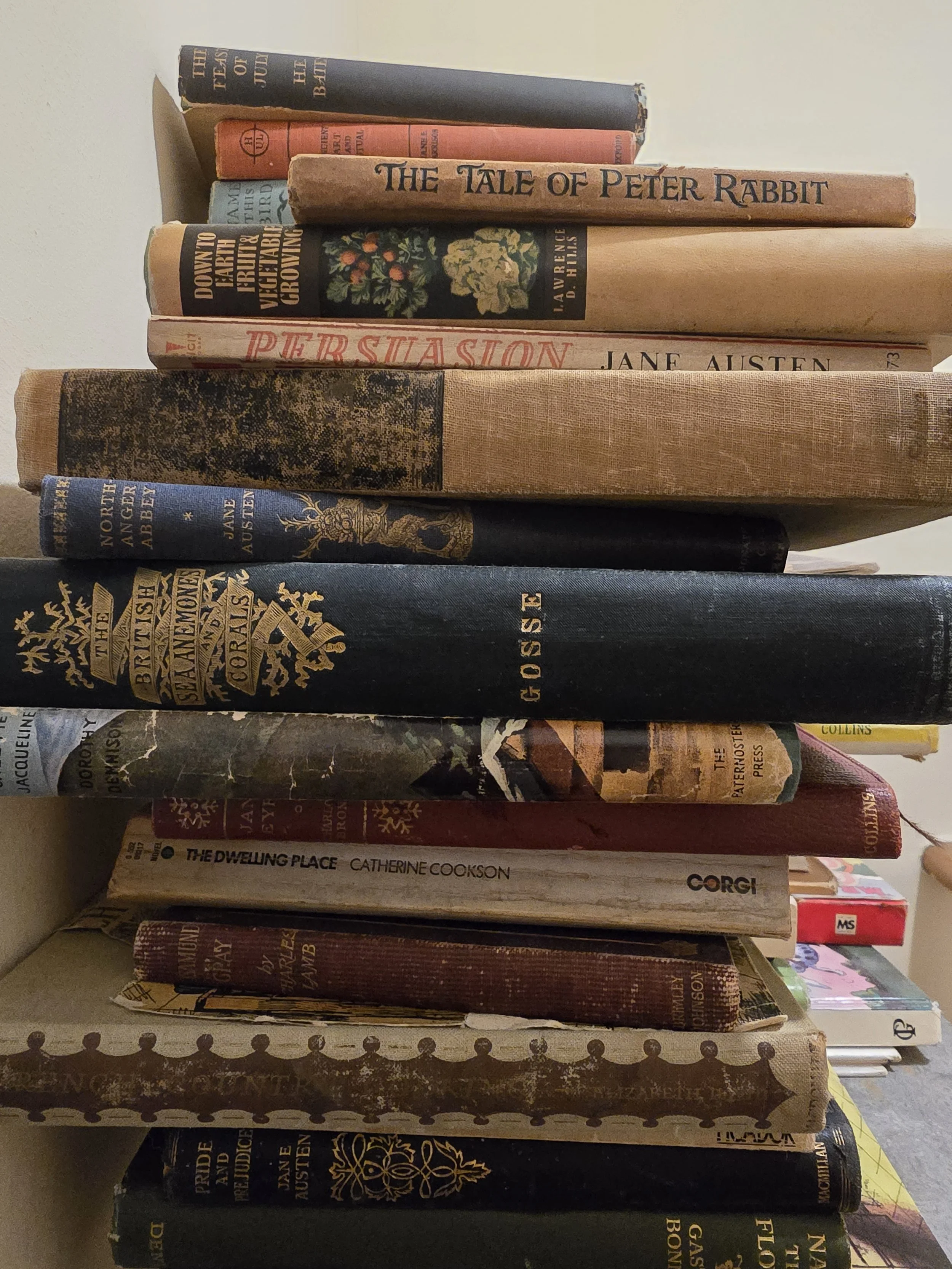 Stack of antique and vintage books with worn bindings and aged pages, styled as a vintage library collection at Pomme de Jour