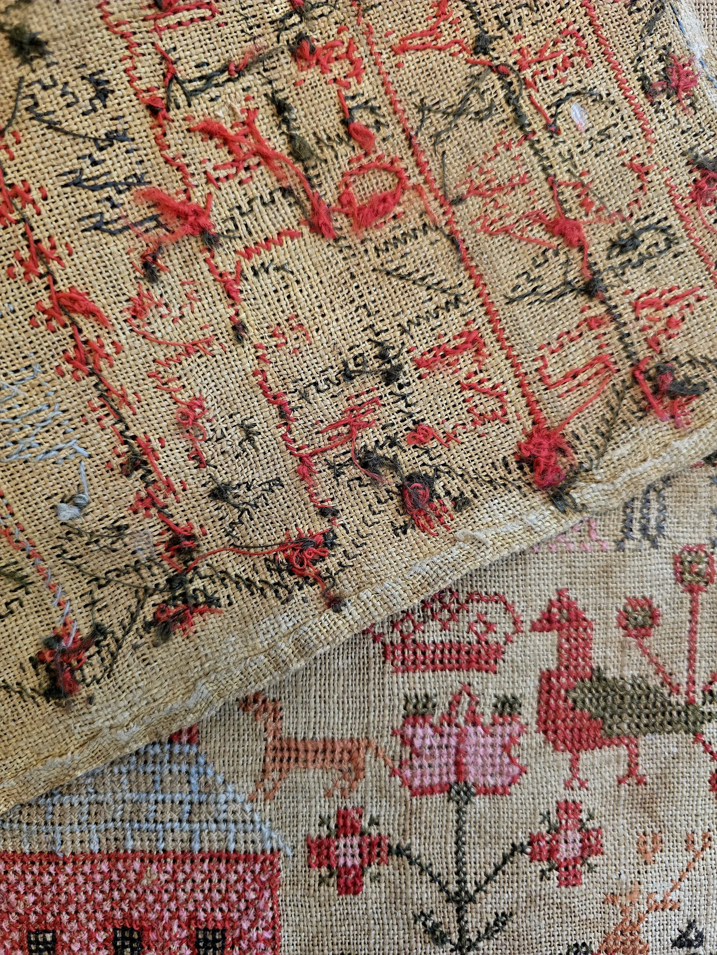 Reverse of the late 18th century Scottish sampler showing the hand stitched construction and age-related character.
