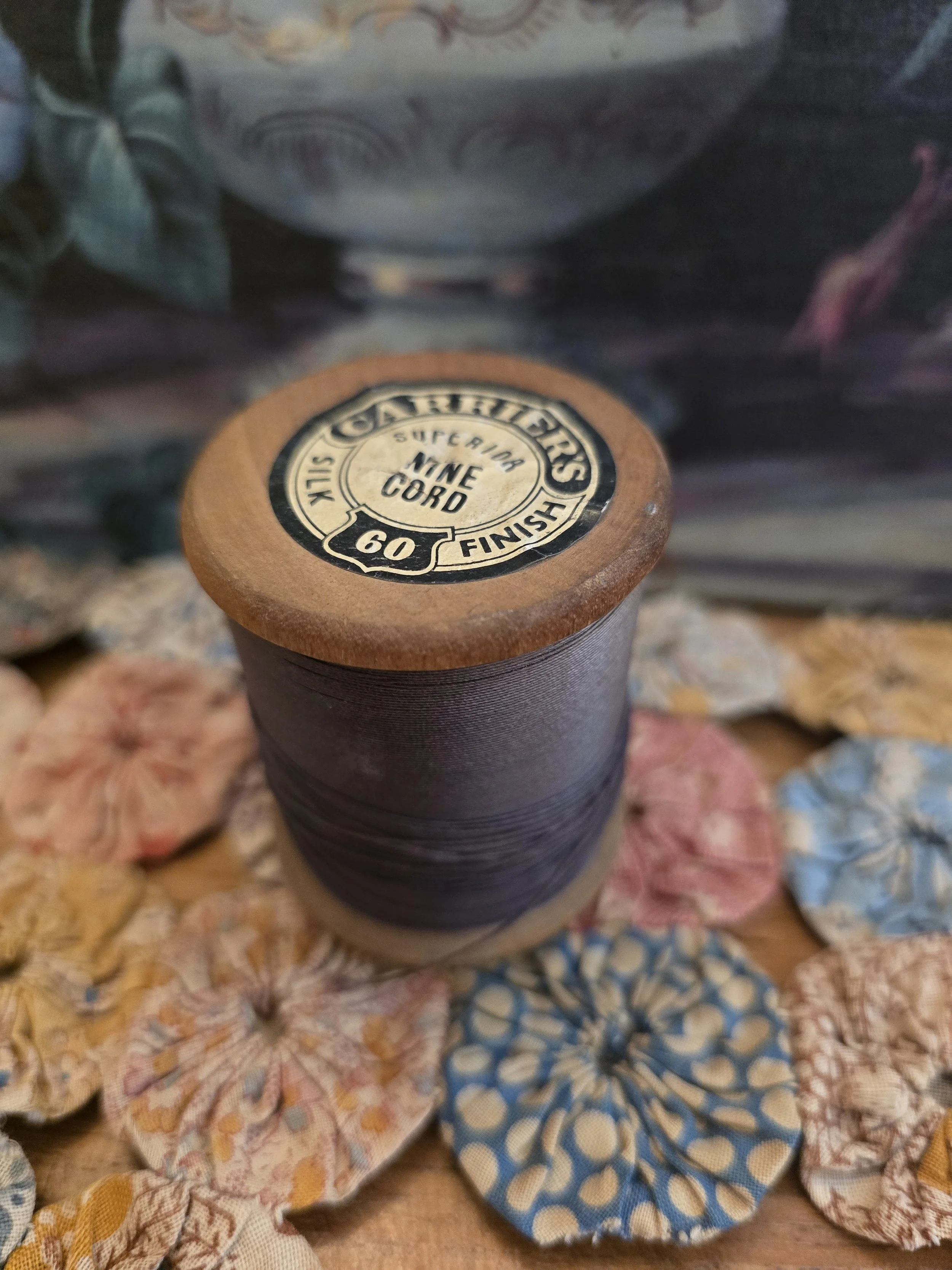 Vintage Carriers Superior Silk Finish Nine Cord thread spool with original label and blue thread on a wooden reel.