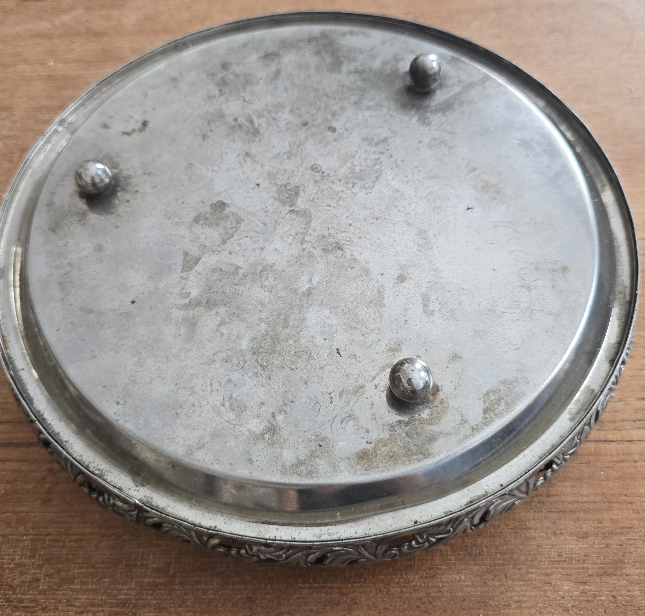 Underside of vintage silver tone tray showing three ball feet