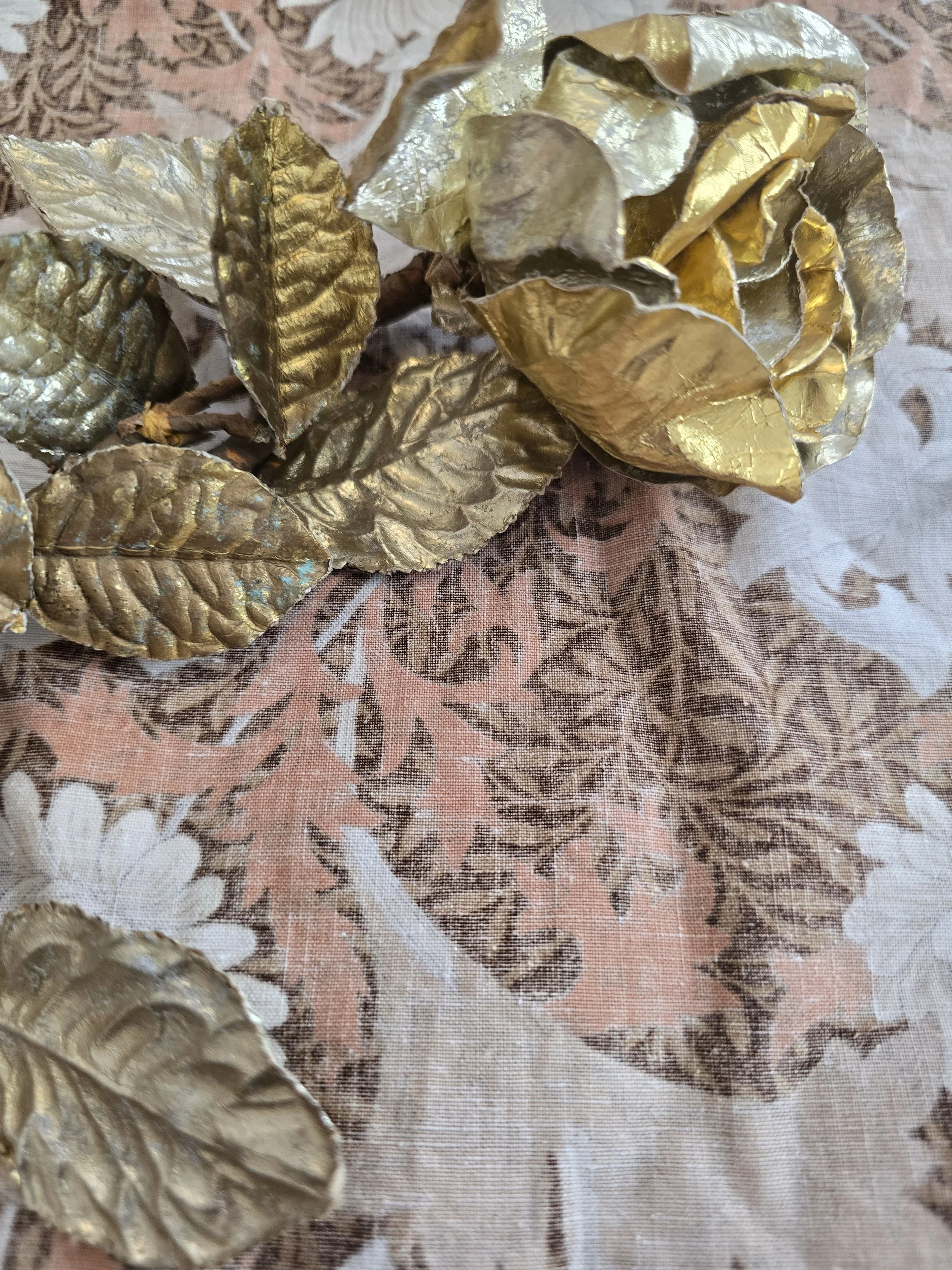 Mid-century decorative floral ornament featuring gold-toned leaves and wrapped stem.