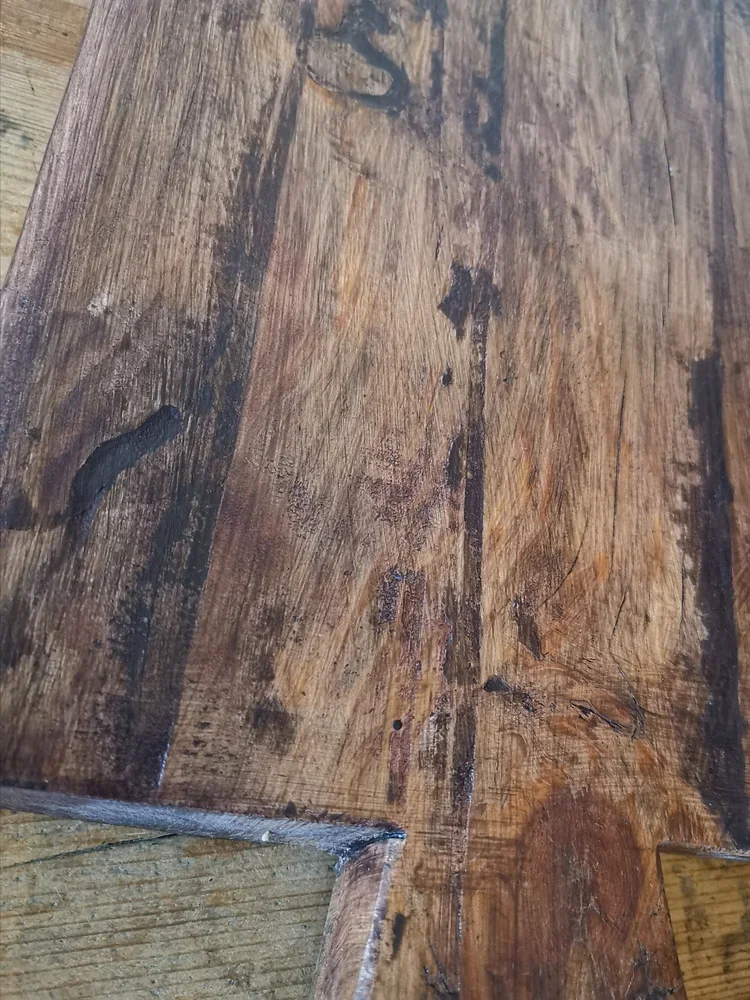 Detailed view of vintage oak cutting board surface with rich patina and knots