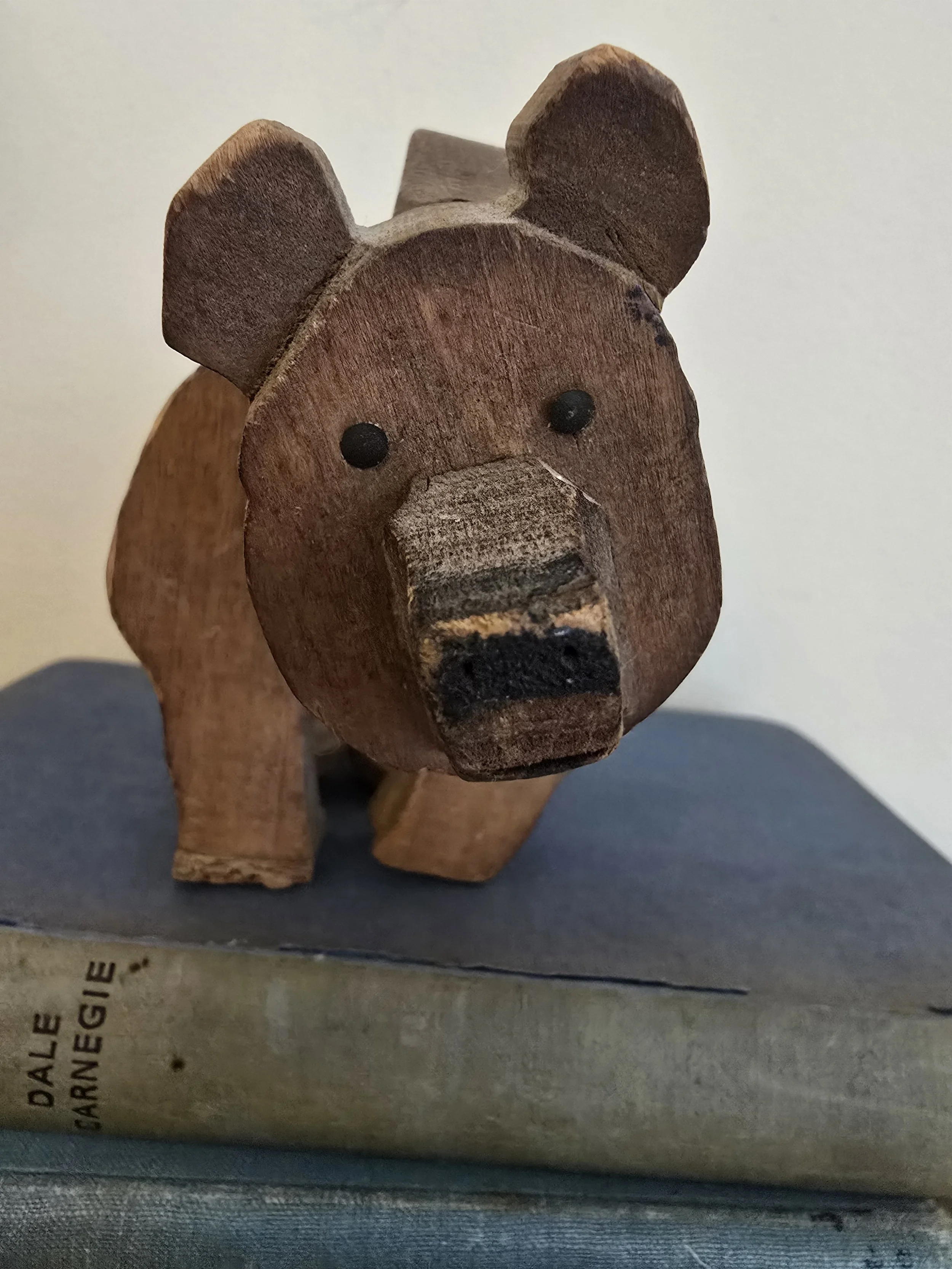Close-up front view of antique articulated wooden toy bear showing its face and carved ears