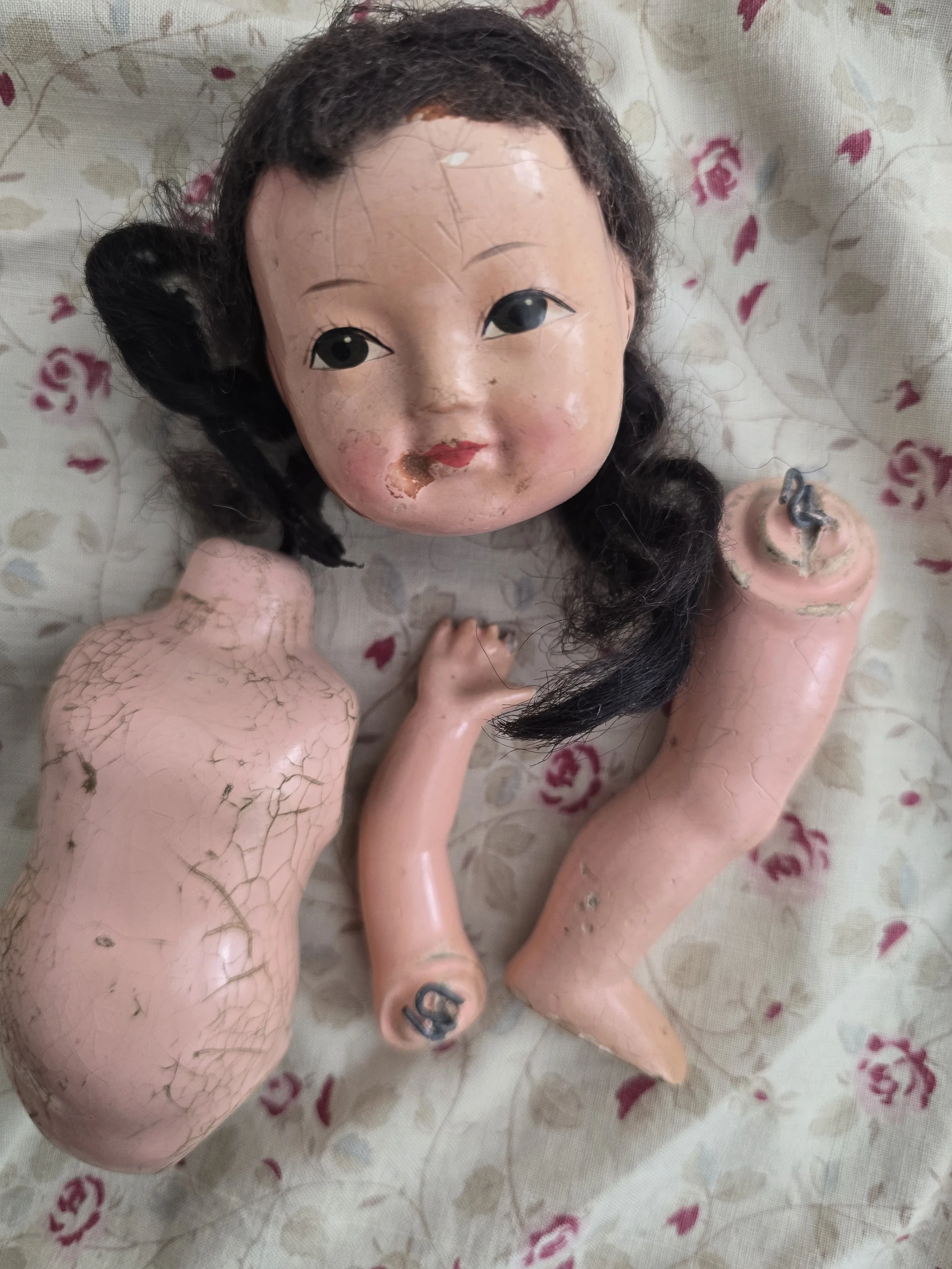 Vintage composition doll parts including head, body, arm and leg.