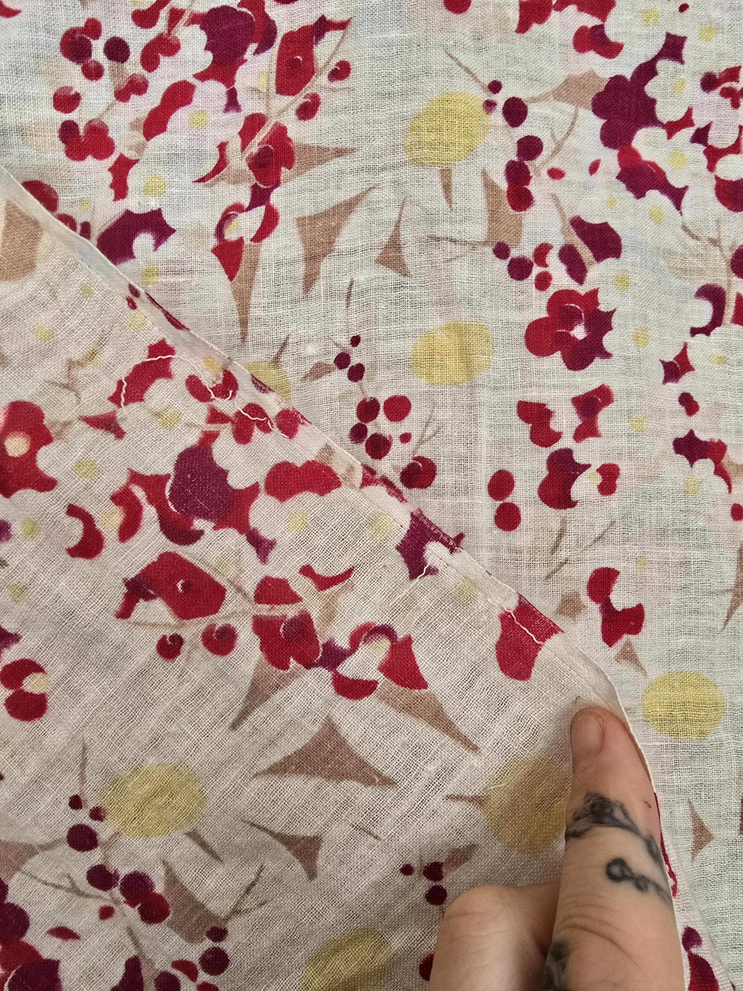 Antique fabric with floating red petals and tan leaves