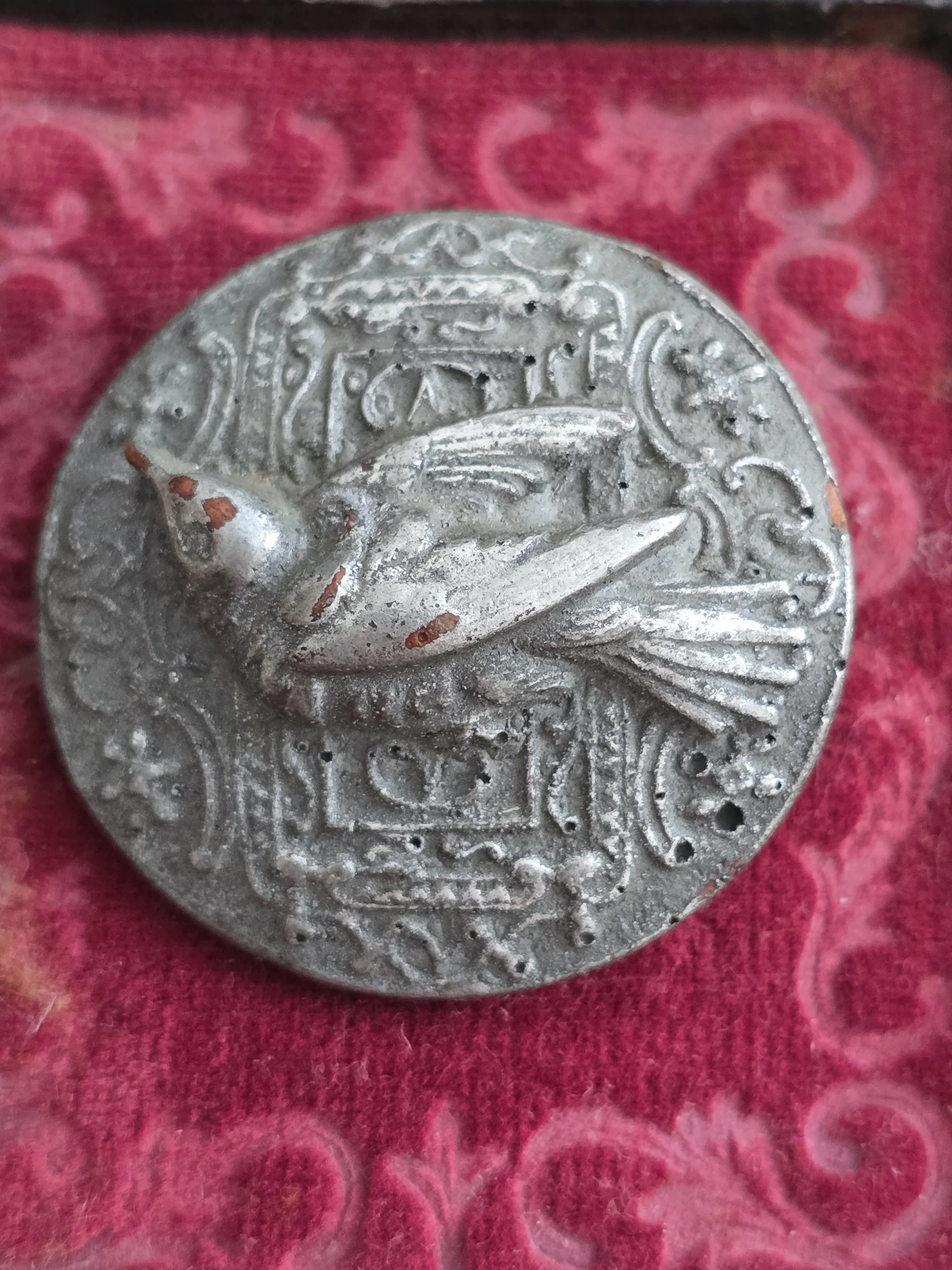 handmade brooch created from an antique bird button with raised swallow motif