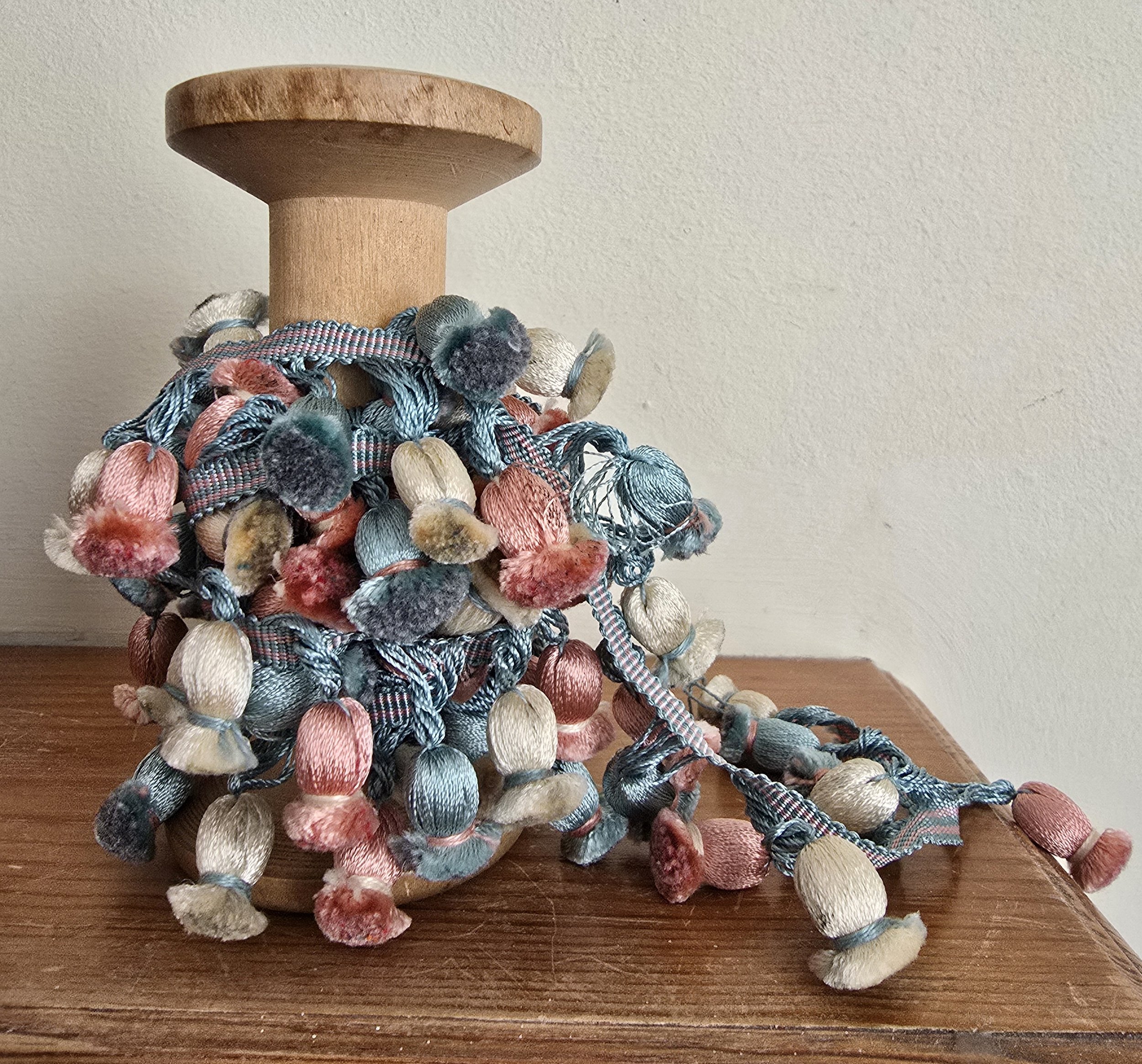 vintage passementerie on wooden spool with sorbet-toned tassels, perfect for styling or sewing