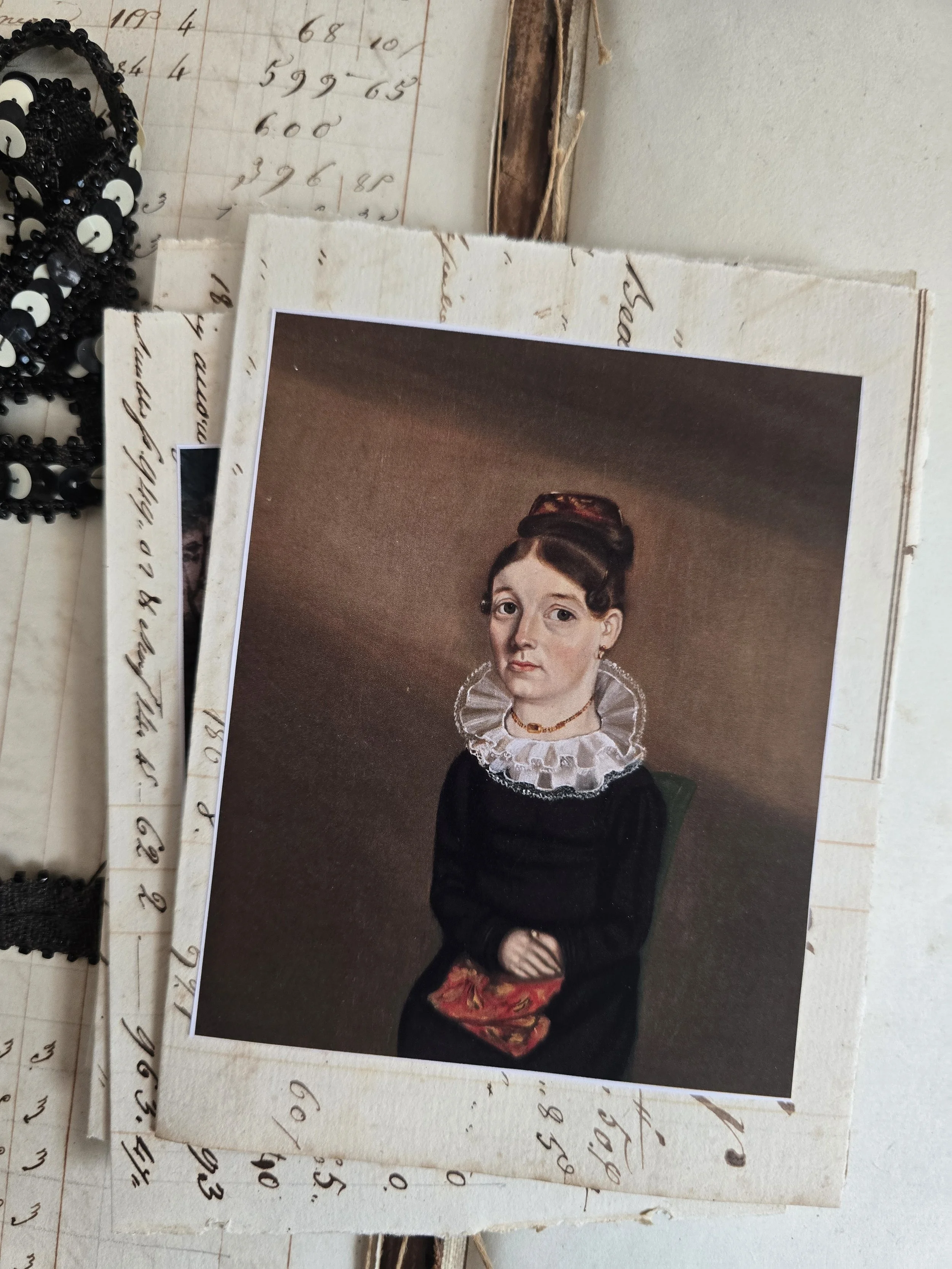 Studio Made card featuring a folk art portrait of a girl in a dark dress, created using genuine antique French ledger paper.