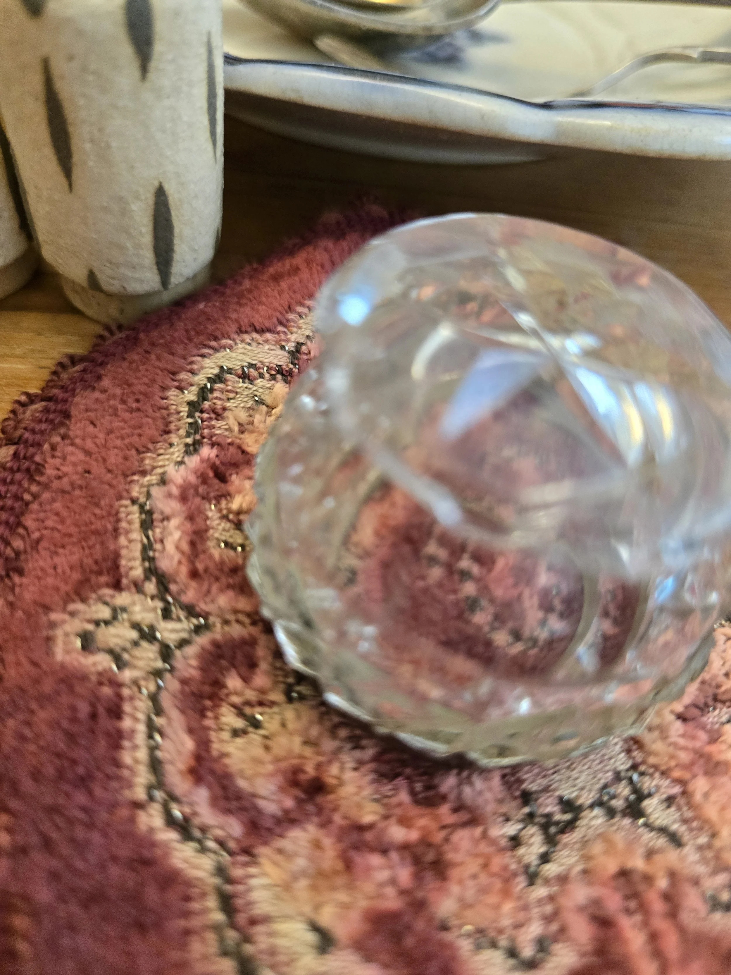 Side view of small antique cut glass and silver salt cellar with geometric faceted decoration.
