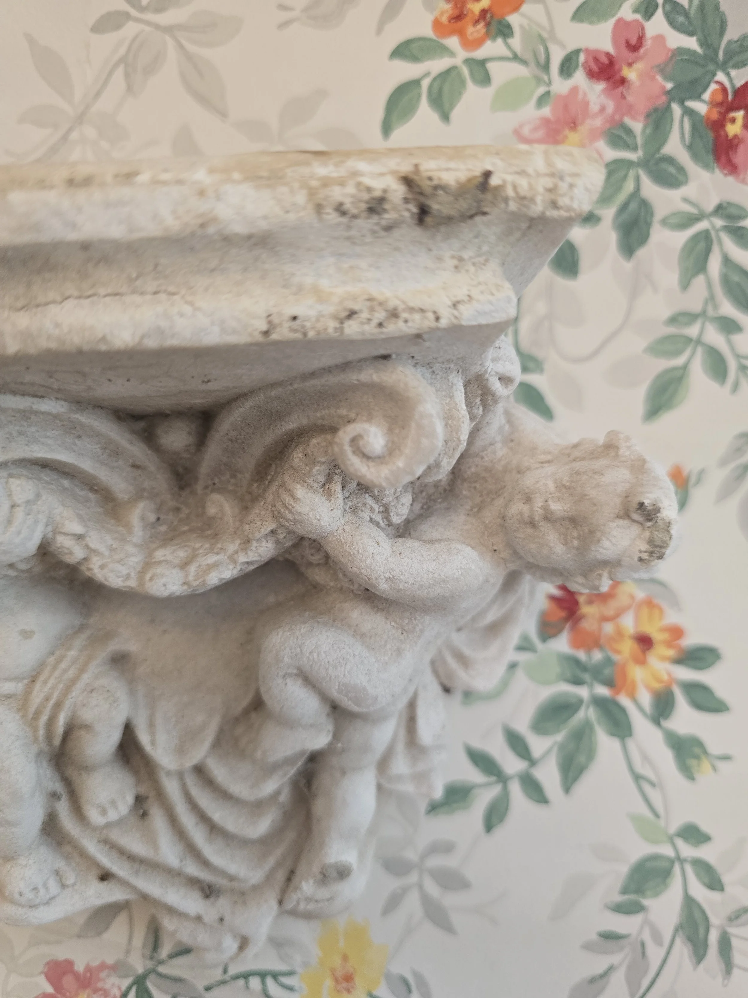 Vintage architectural fragment with putti figures and scrollwork detail