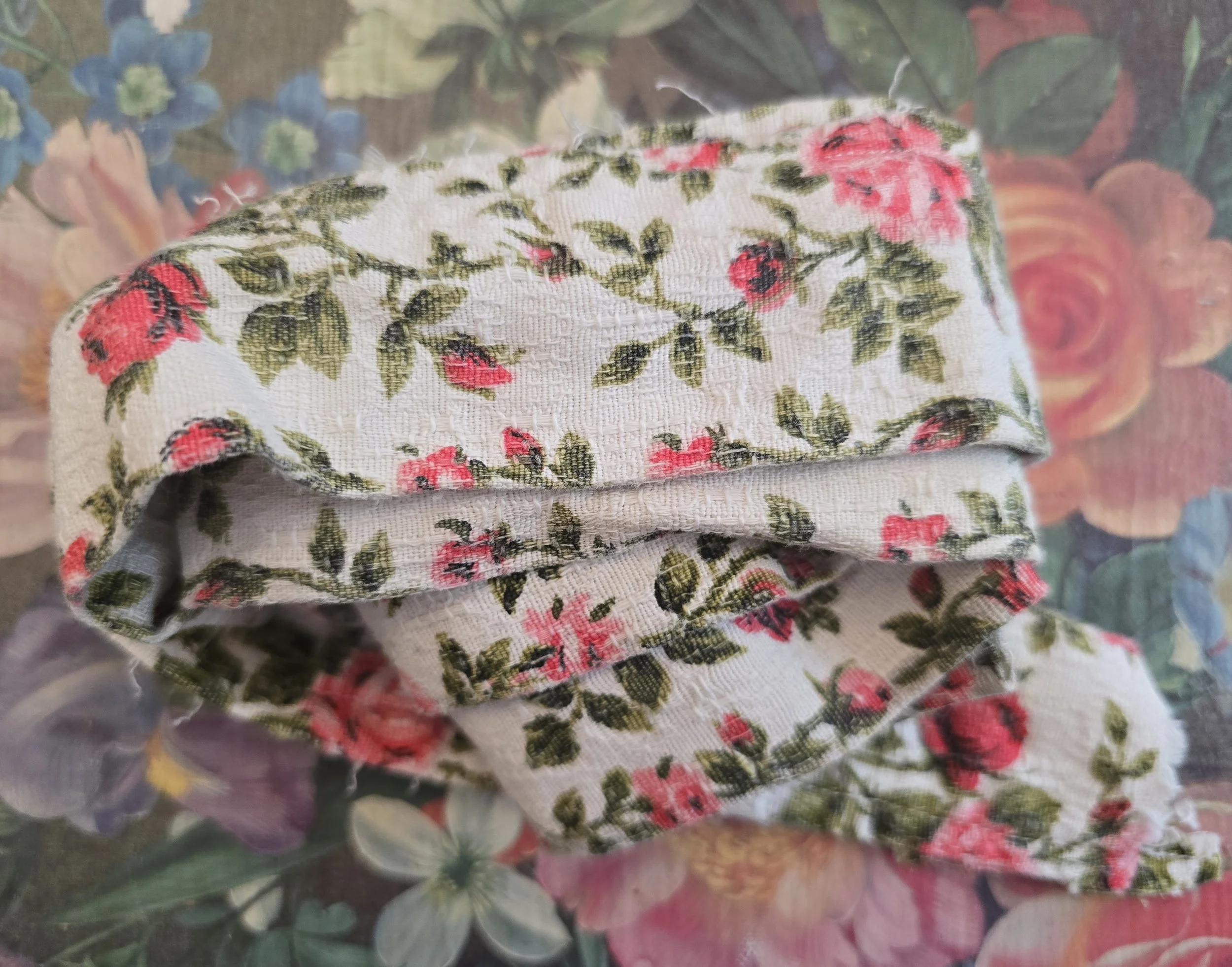 Vintage French barkcloth trim with pink rosebud floral design on cream background.
