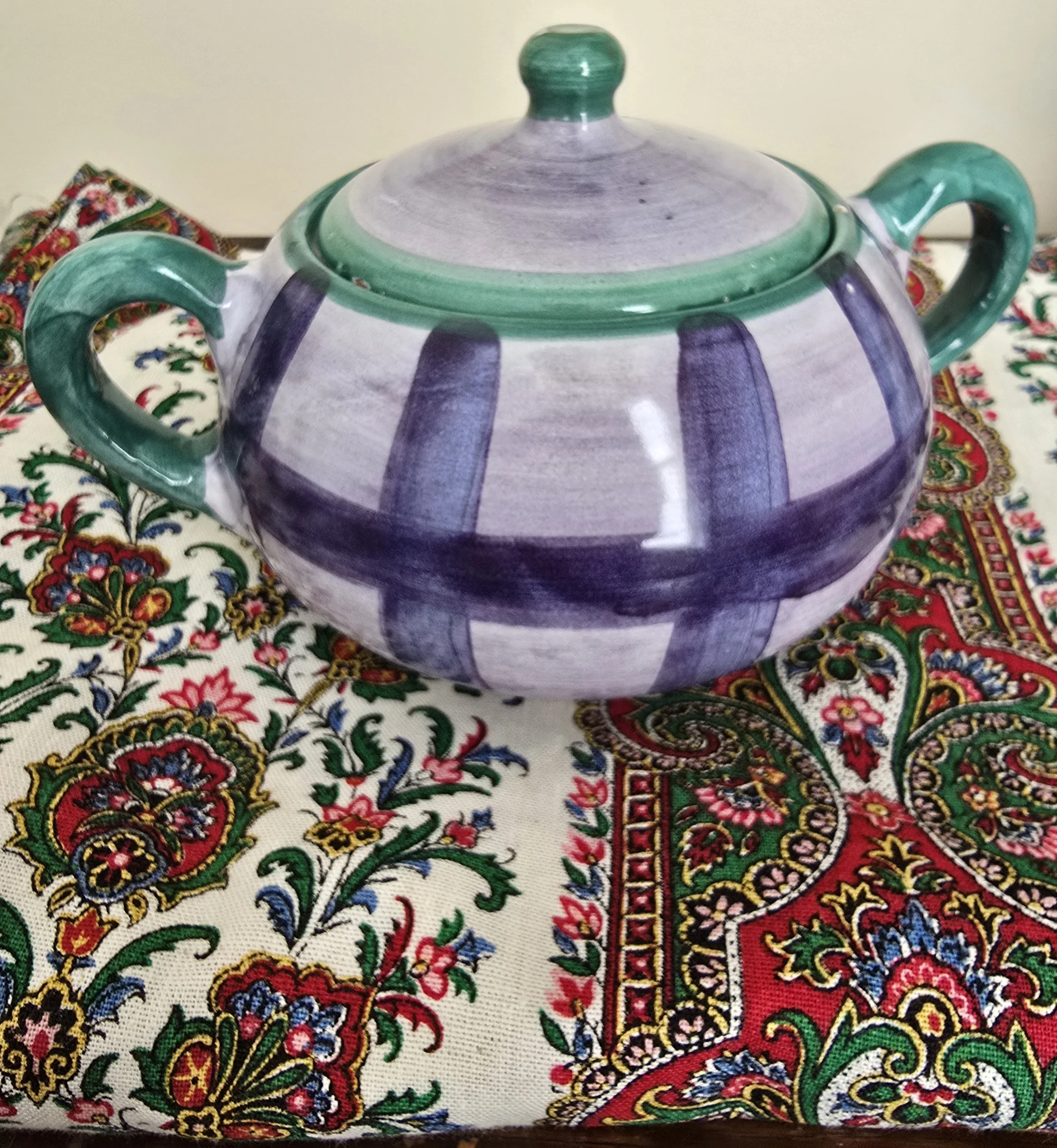 Overhead view of Italian sugar bowl with green handles and matching lid