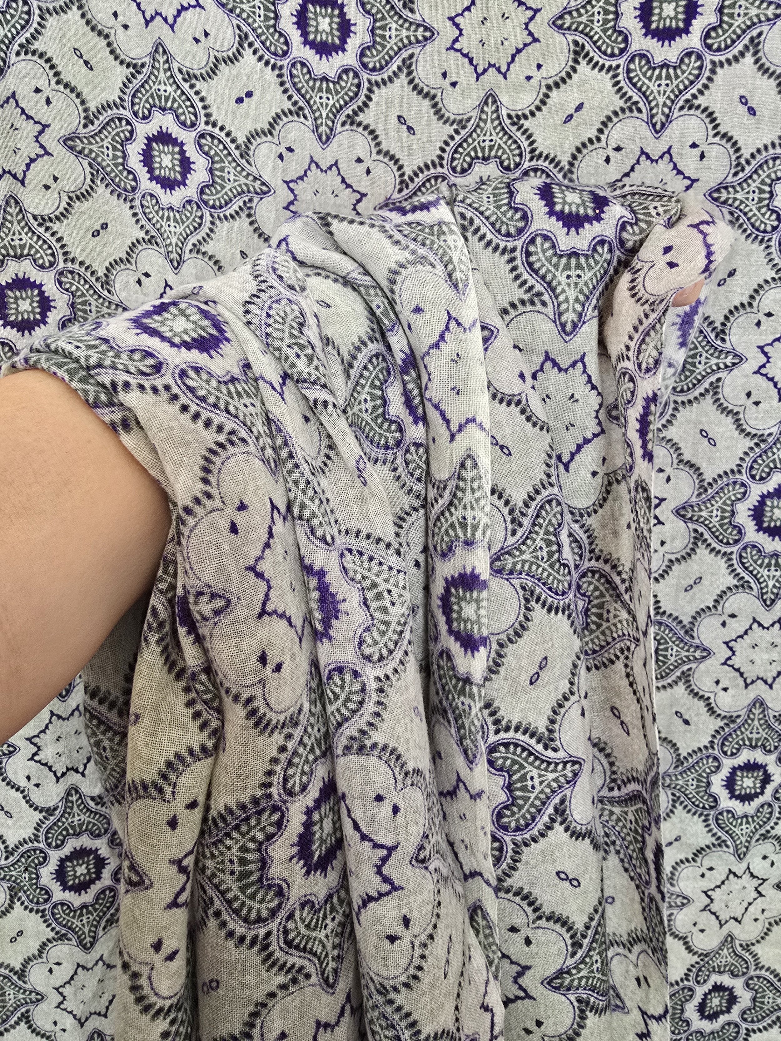 Draped display: The Souleiado fabric draped over a chair, demonstrating its flowing, fluid drape and giving a sense of how it might look in use or in decor.