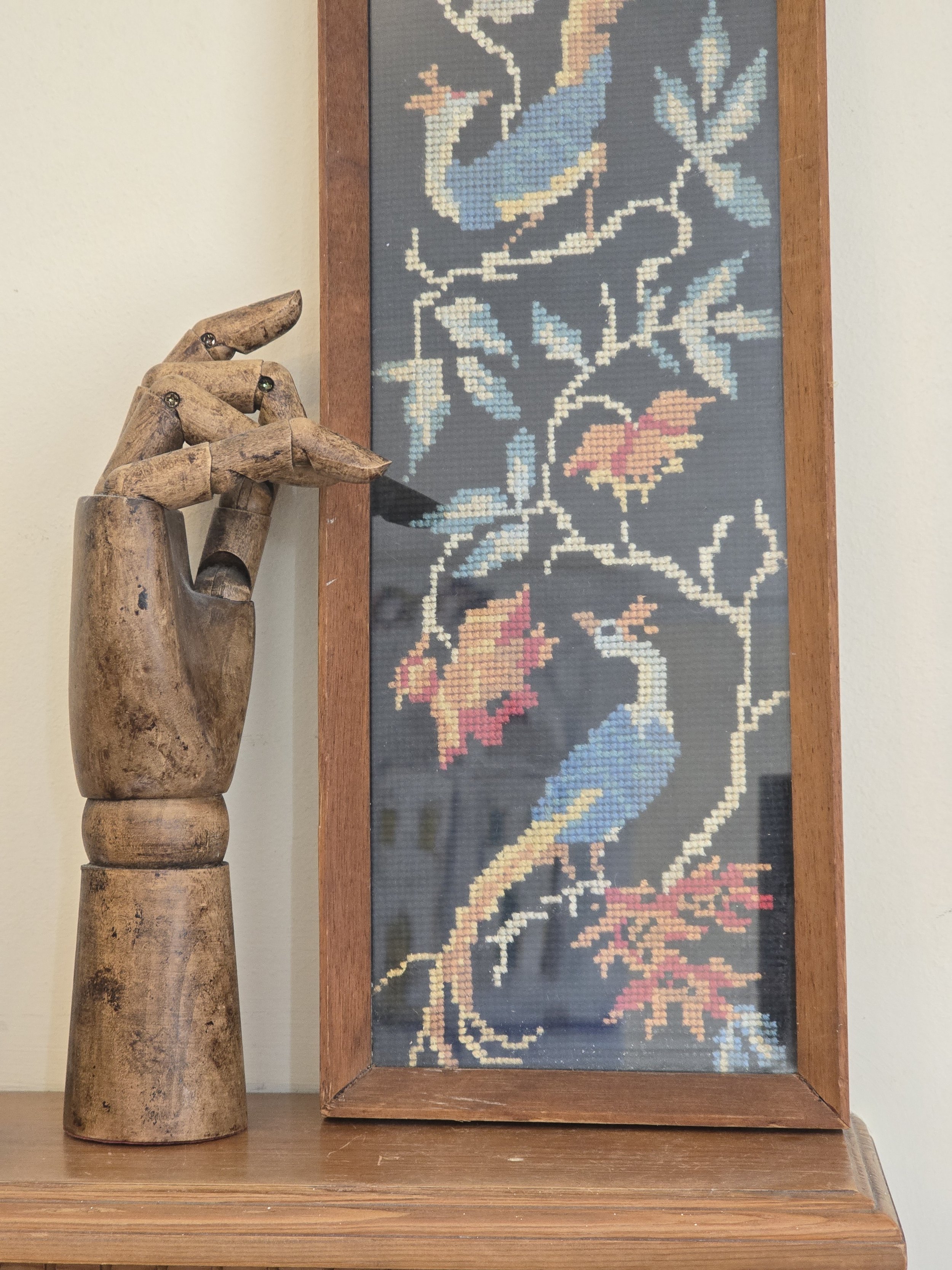 Long narrow vintage peacock needlework in a simple wooden frame