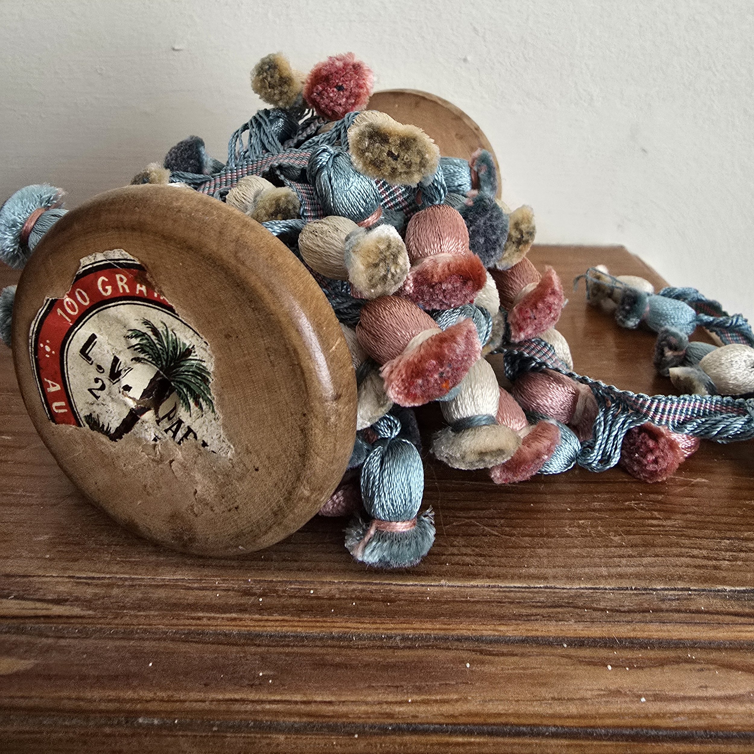 old wooden spool wrapped in vintage French passementerie ribbon with original label fragment
