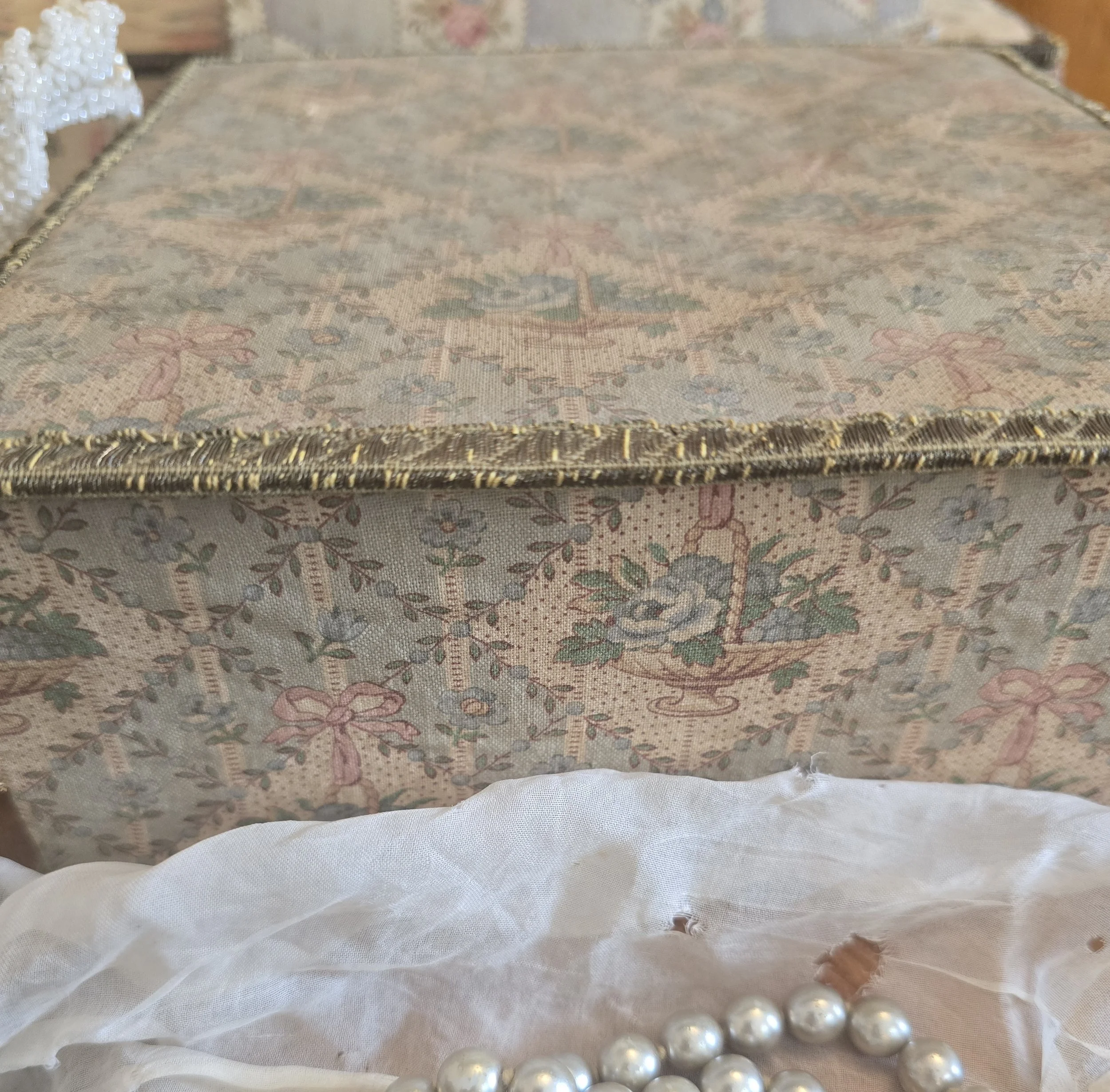Antique French floral fabric-covered boudoir box with faded blue, pink and cream rose basket design.
