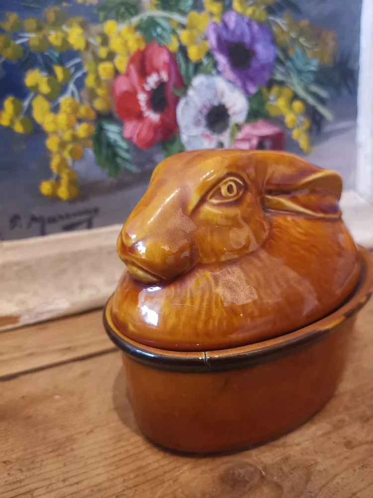 Side view of rustic French rabbit terrine showing glazed ceramic dish