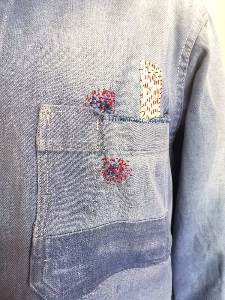 Left sleeve showing visible repair and fabric blending