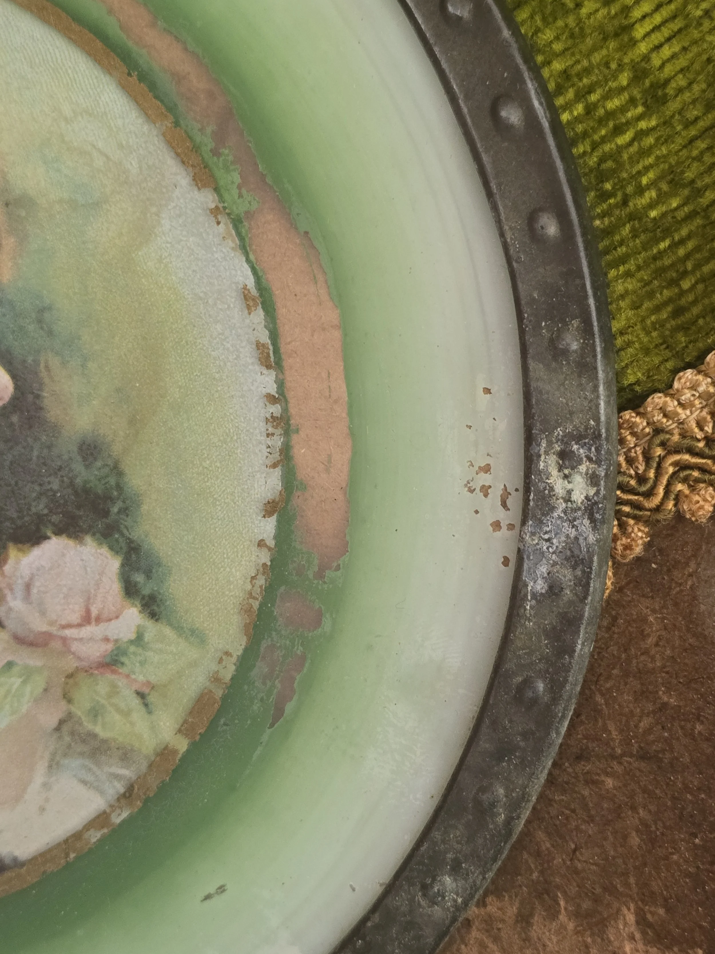 Decorative antique wall hanging with green shaded glass surround.
