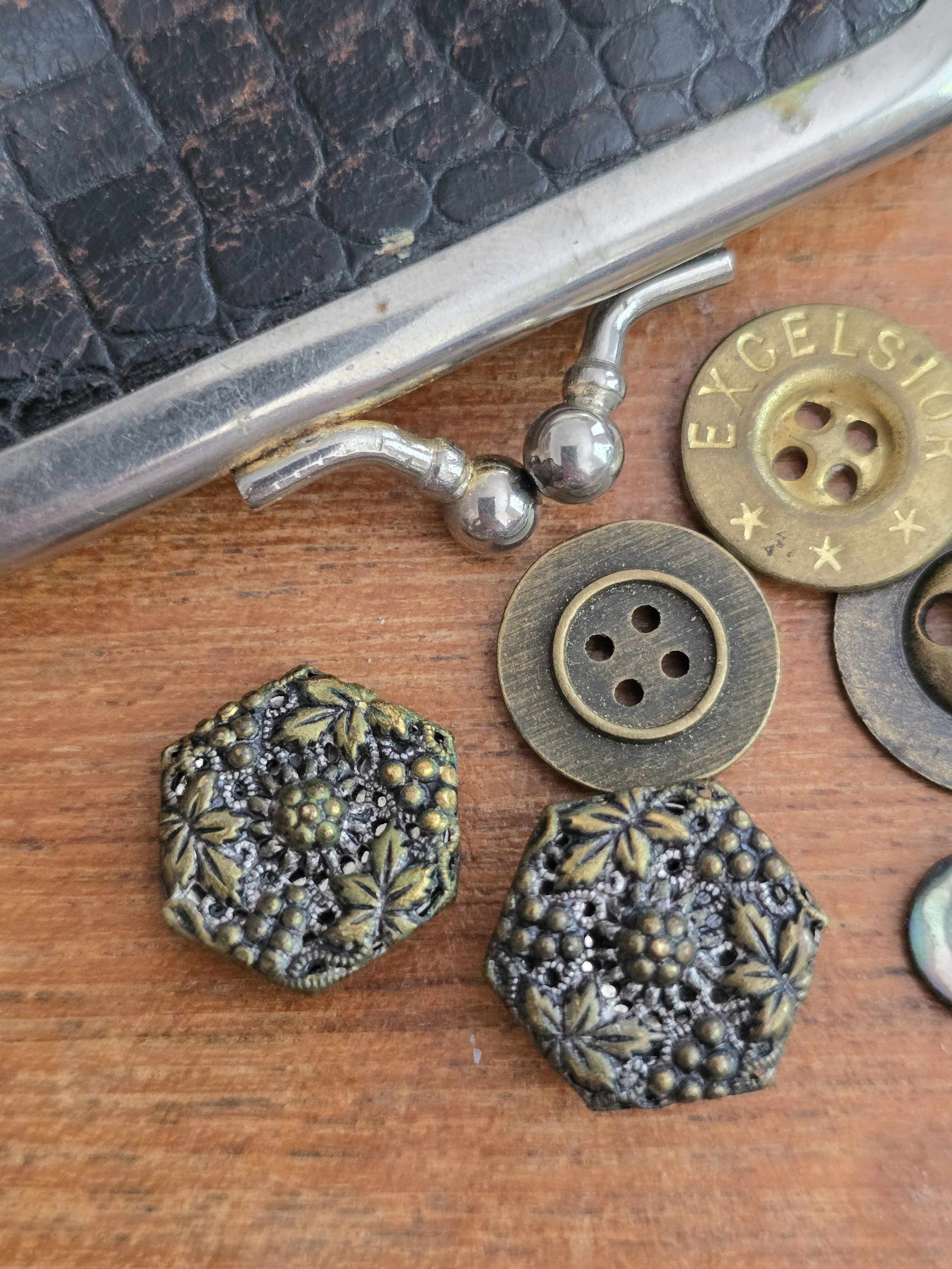 Antique brass-toned floral buttons with intricate pierced design and original shanks.