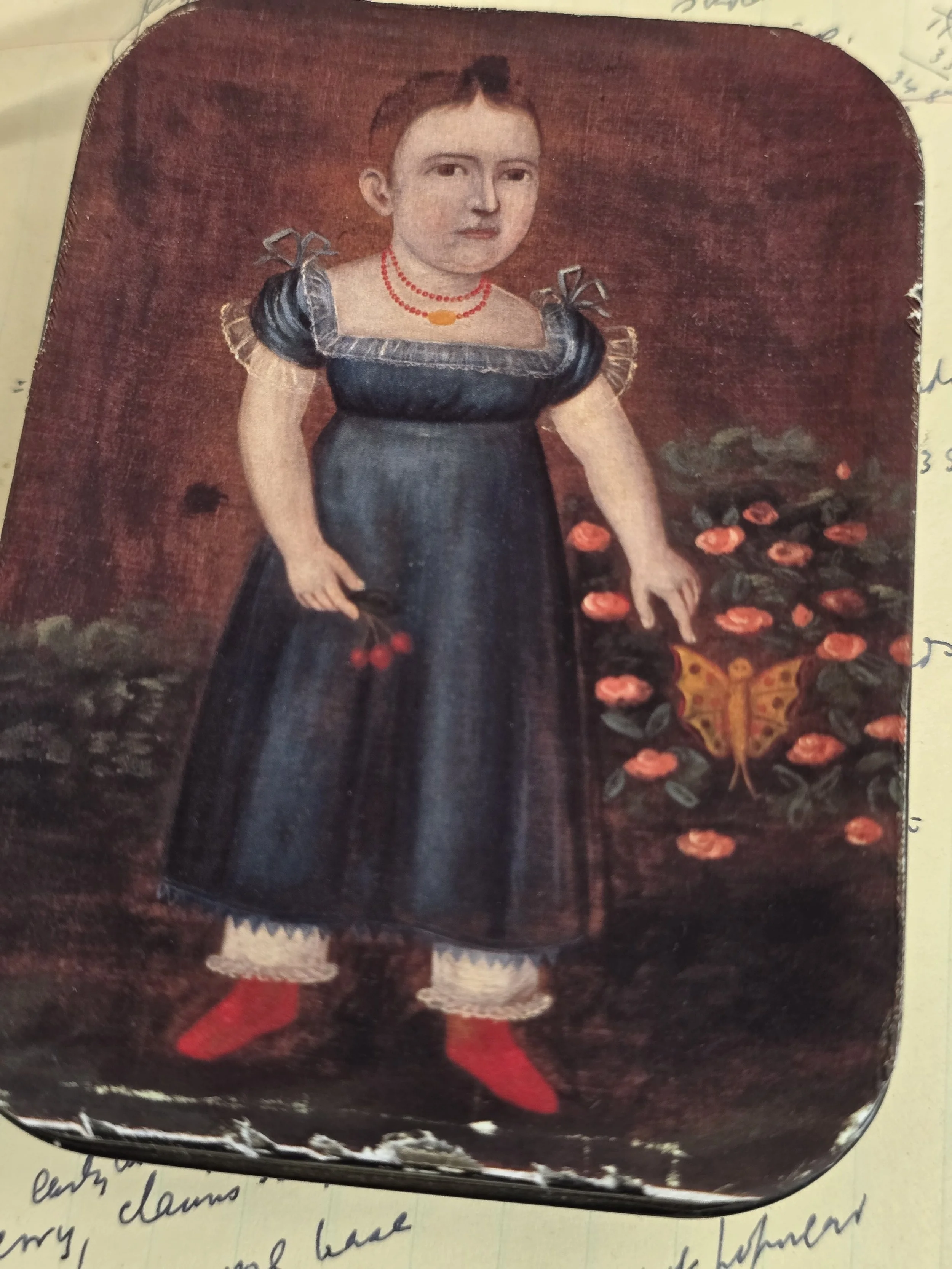 Folk art child portrait applied to an antique metal tin with original patina.