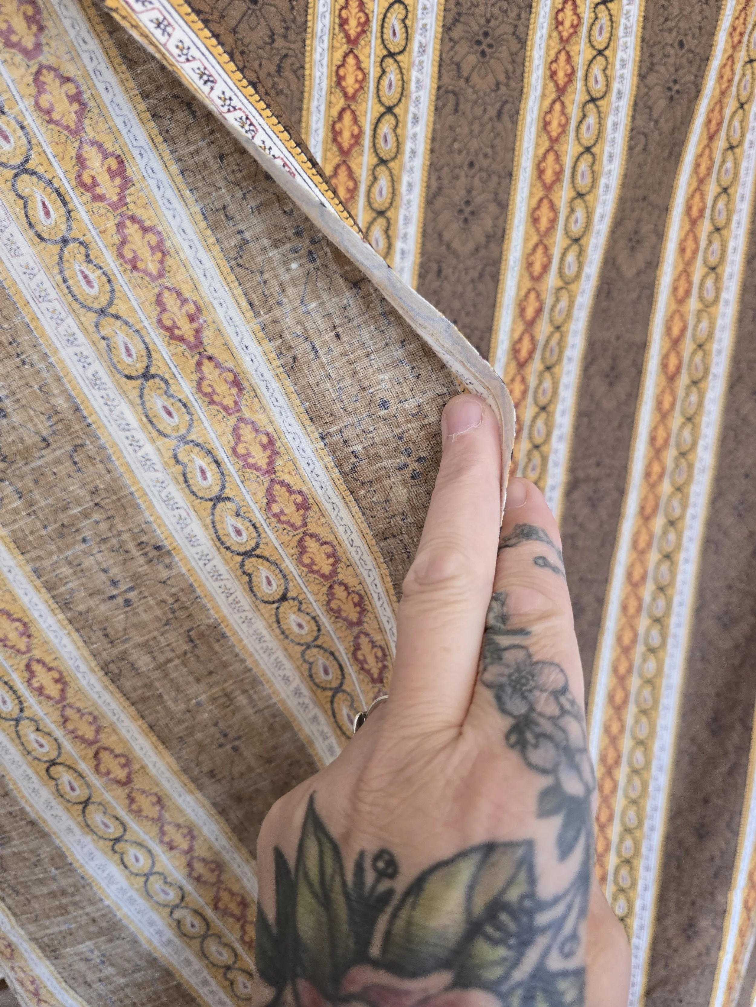 Detail of the subtle tonal floral pattern printed within the broad brown stripes.